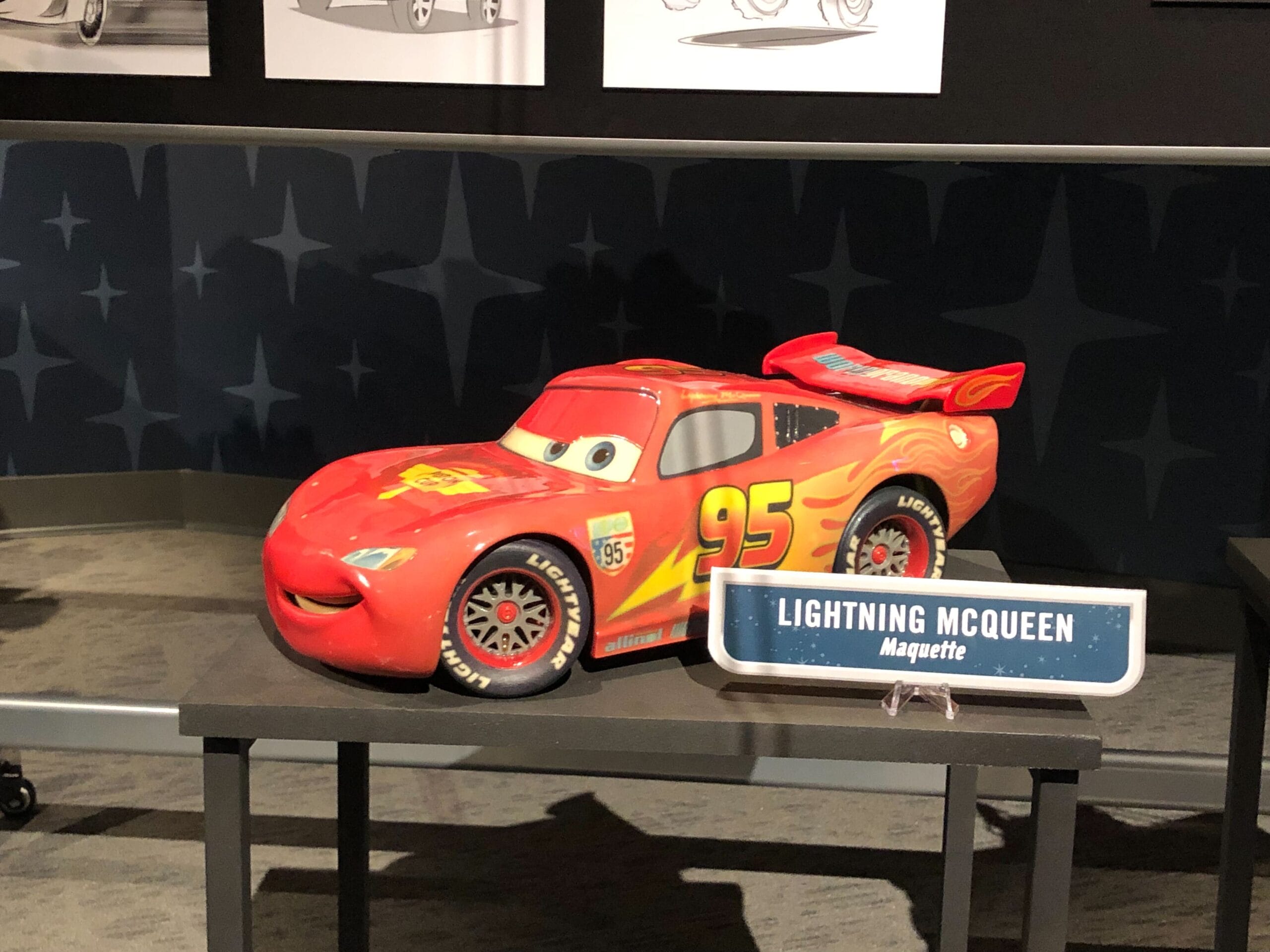 A model of Lightning McQueen from Cars sits on a table, evoking the vibrant Cars Land atmosphere found in Disney parks.