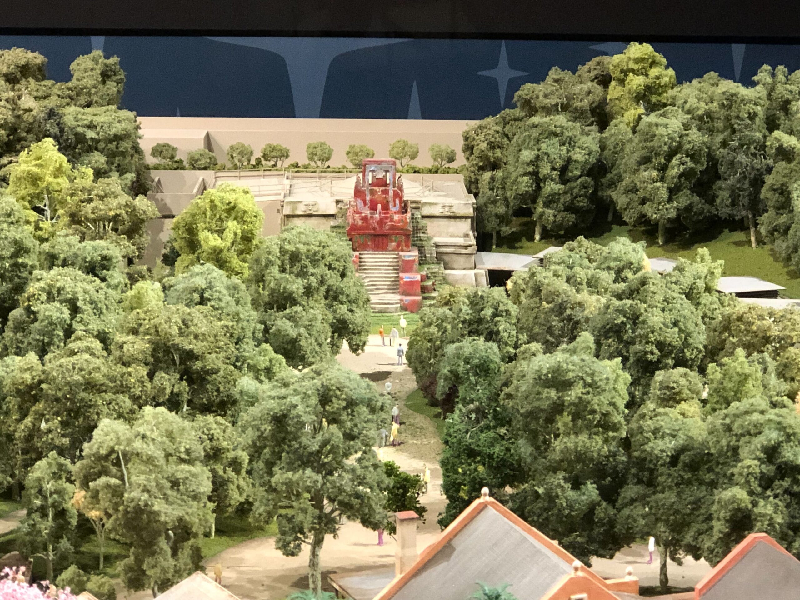 A miniature ancient temple model in Animal Kingdom, with lush trees and a red staircase—distinct from any Disney castle worldwide.