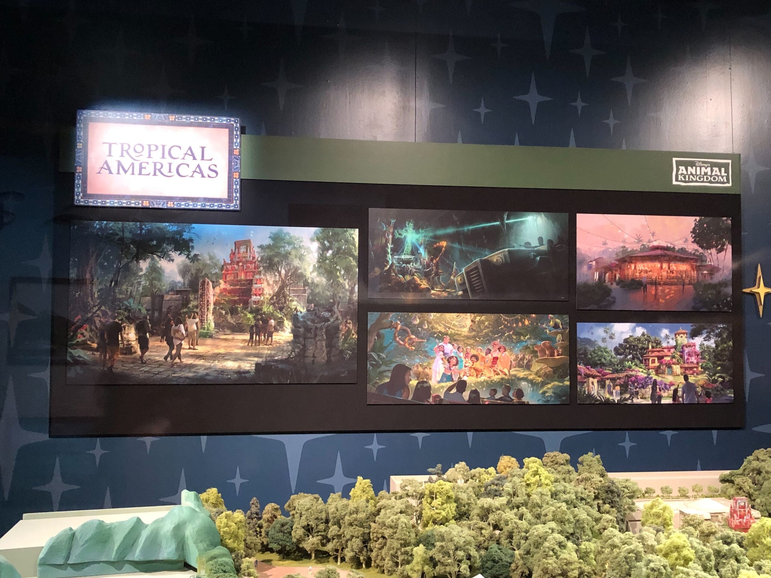 Display board reading "Tropical Americas" shows concept art and a model for Animal Kingdom’s upcoming area, no castle in view.
