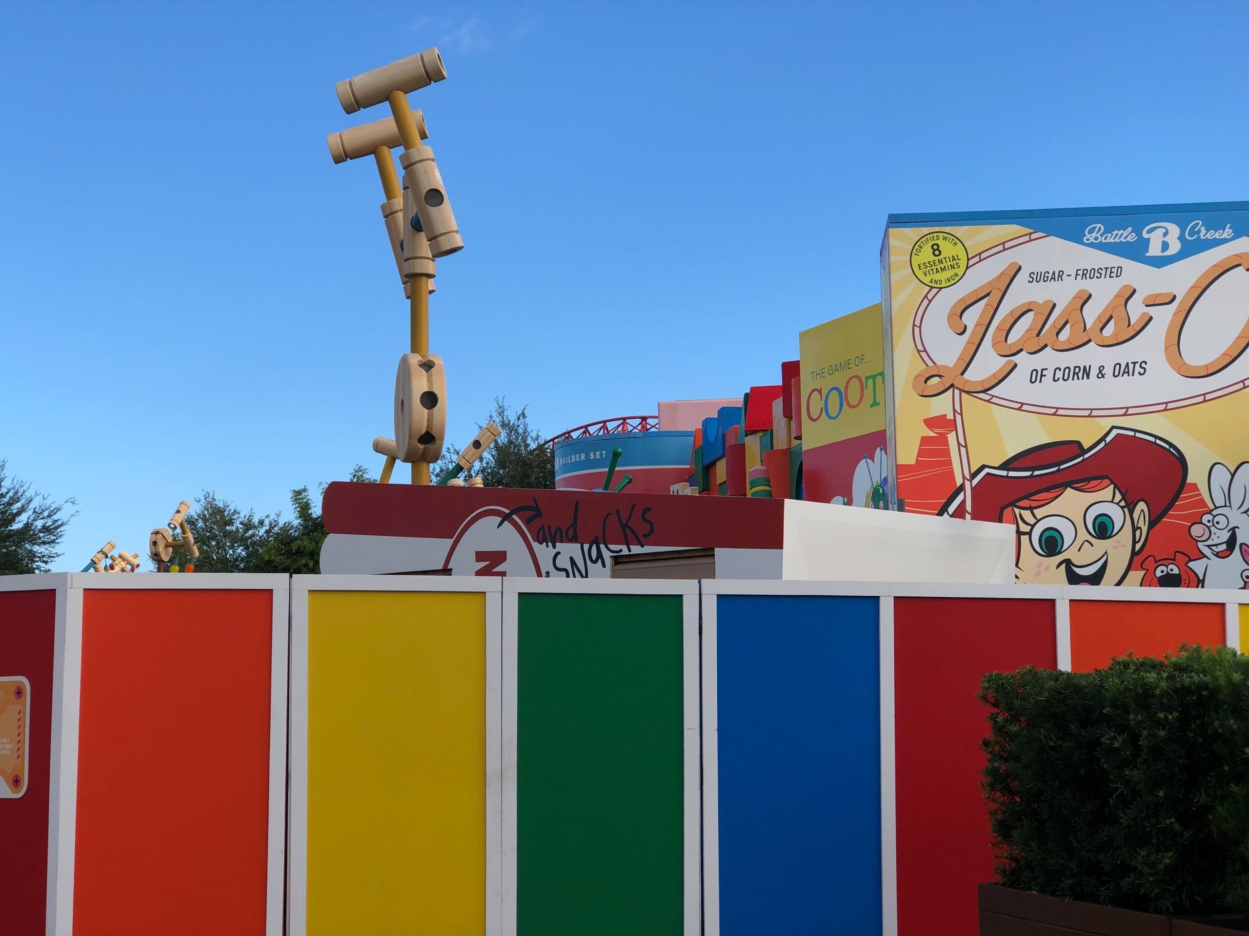 Toy Story-themed construction wall at a Disney park, featuring playful decor and oversized binoculars, no castle visible to compare.