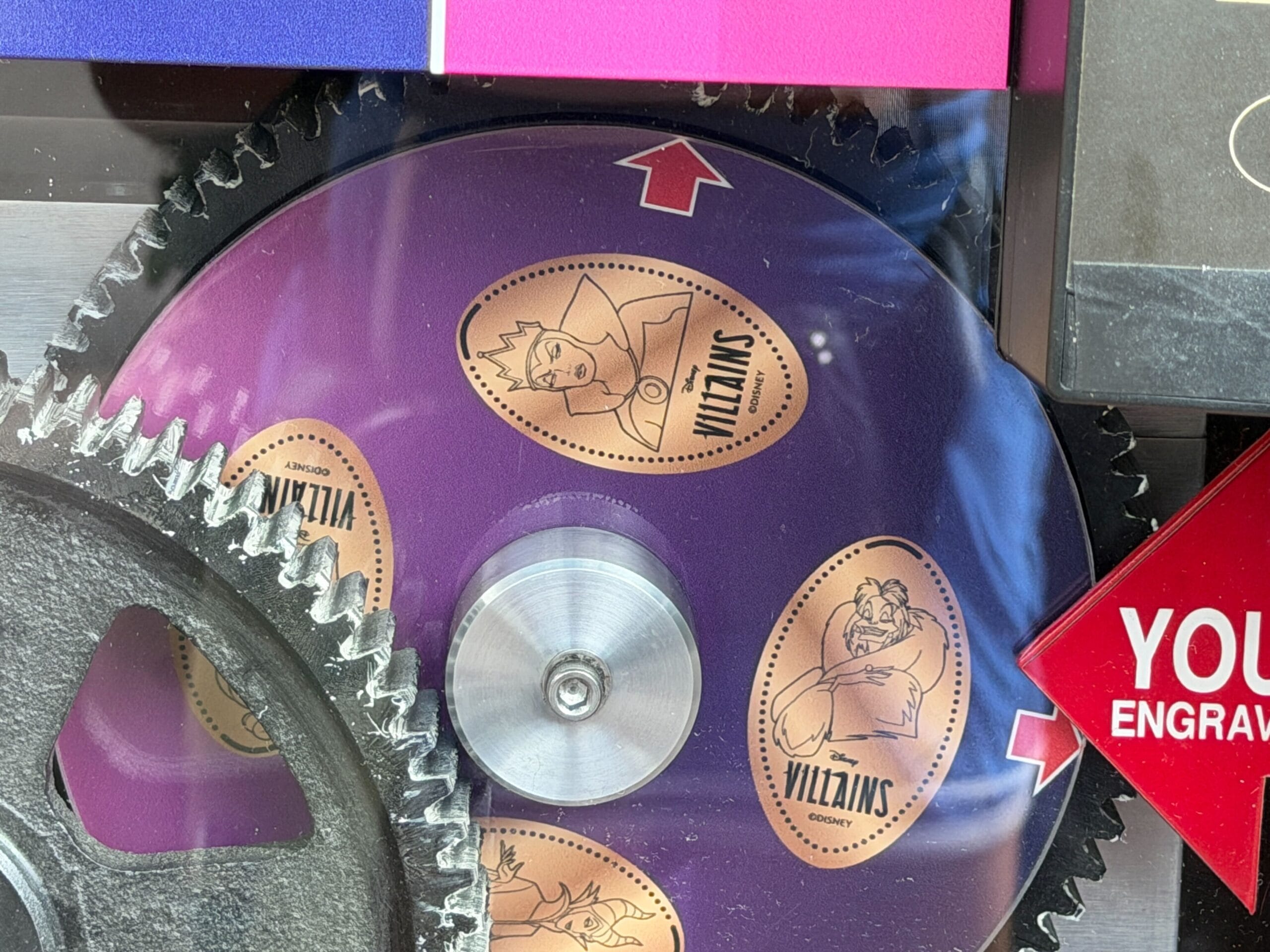 A purple gear featuring Disney Villains like the Evil Queen and Ursula, near silver cogs—Disney Parks-inspired villain art.