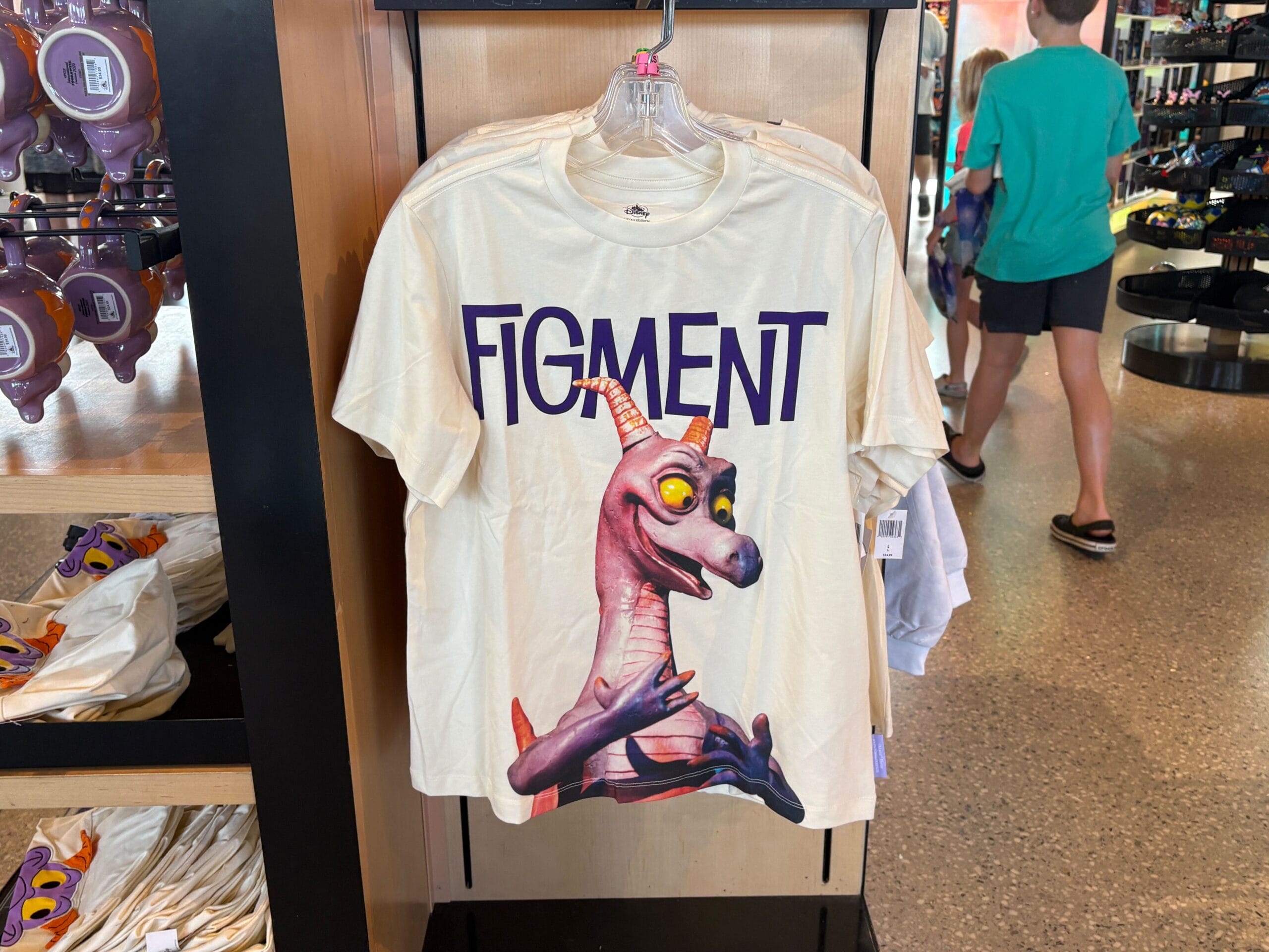 A white T-shirt featuring the purple dragon Figment and the word "FIGMENT" in large letters above him.