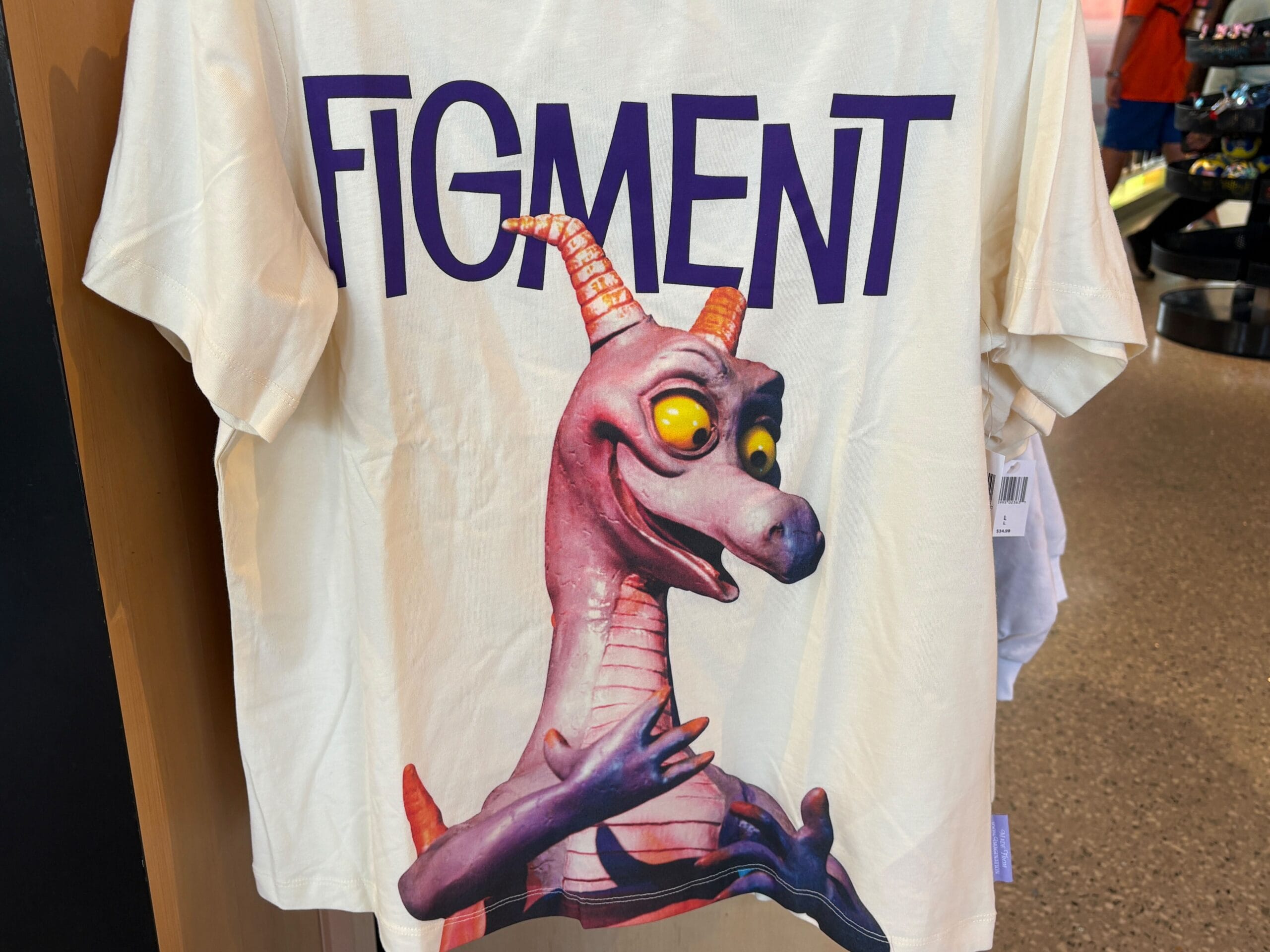 White t-shirt with a Figment animatronic image and the word "FIGMENT" printed above in bold letters.