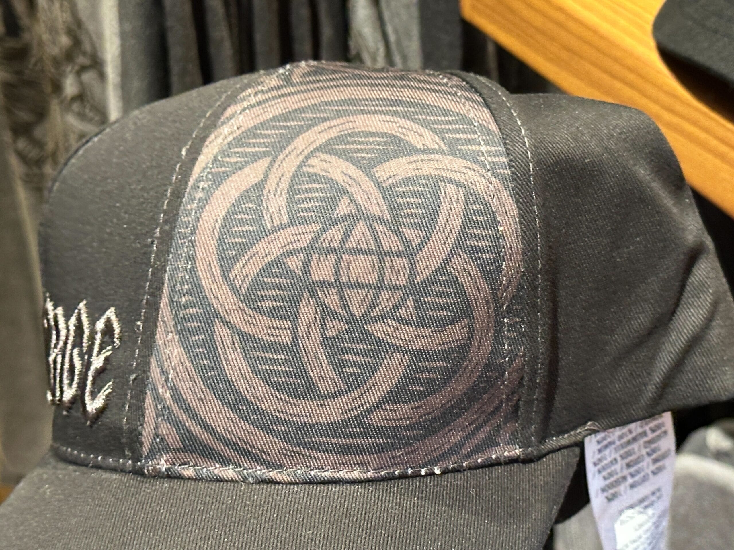 A black cap with an intricate circular Epcot logo-inspired pattern on the front.