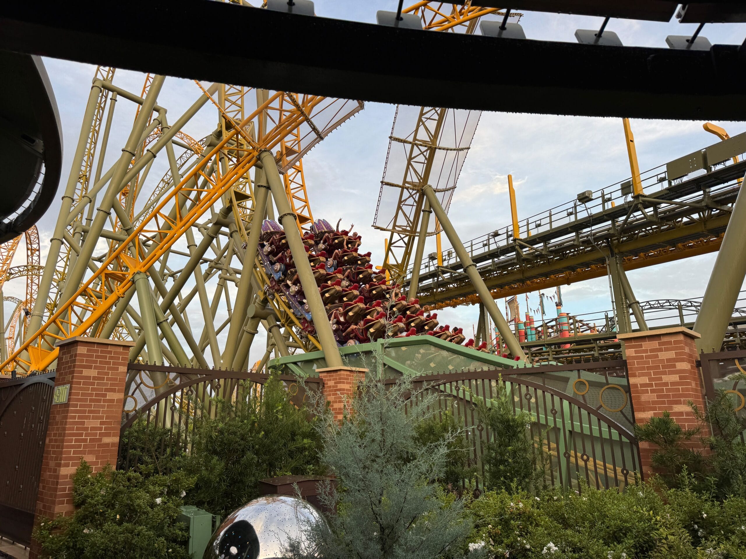 The Stardust Racers roller coaster with yellow tracks twists through greenery at Epic Universe after its reopening.
