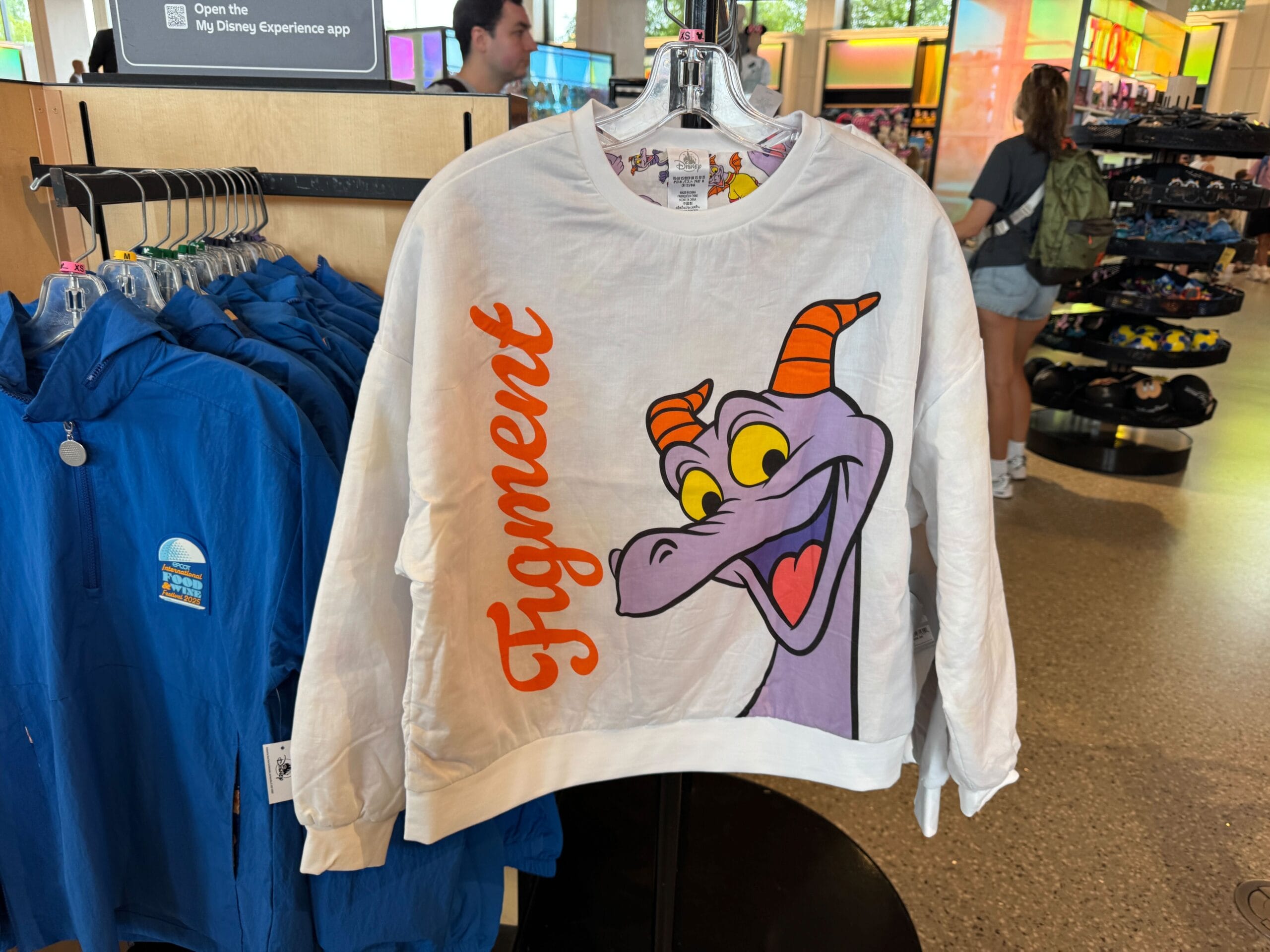 White sweatshirt with a large image of Figment, the purple dragon, and the word "Figment" in orange script on the front.
