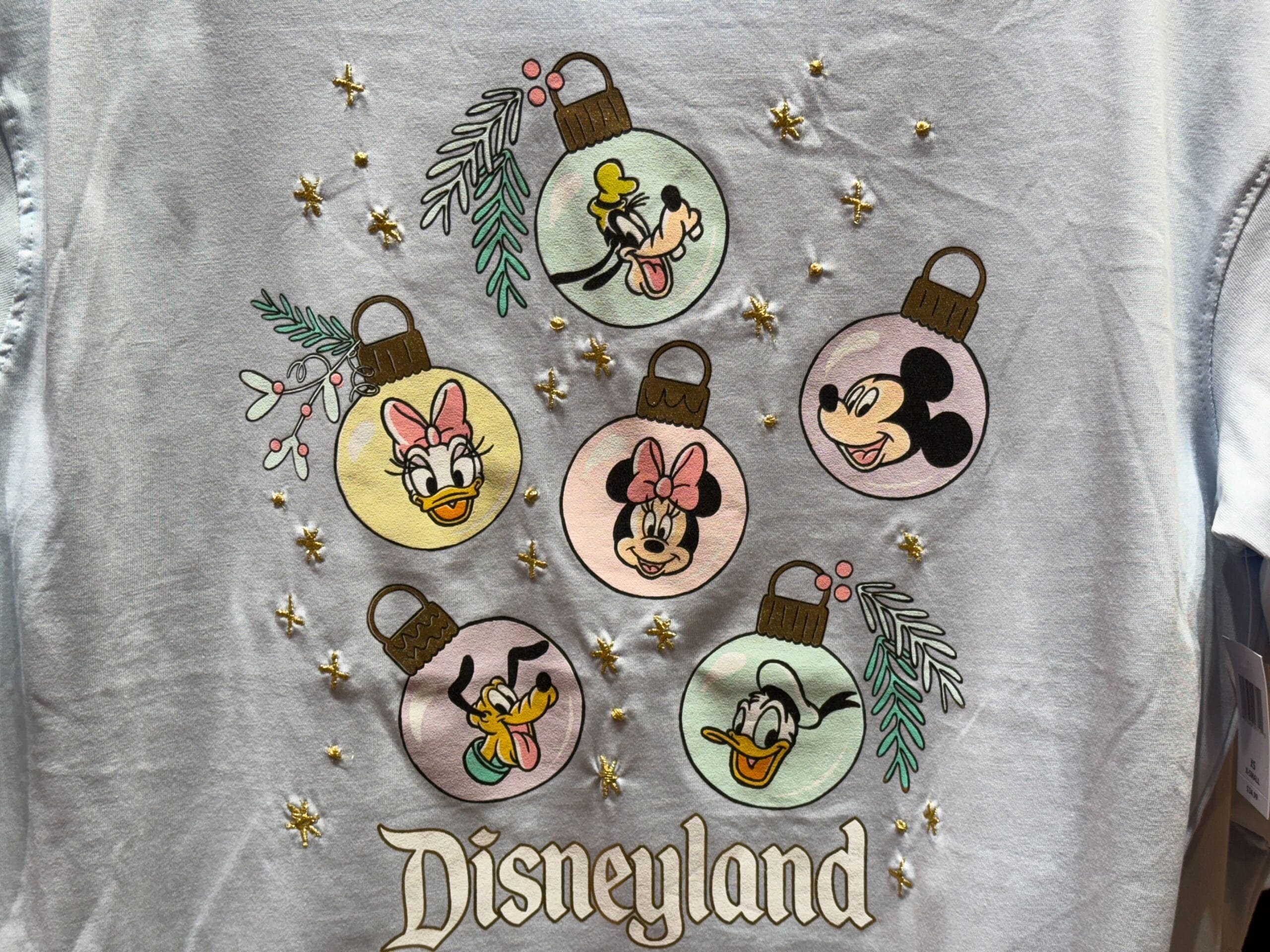 Disneyland holiday shirt with Minnie, Mickey, and friends above "Disneyland" text, referencing the classic California park.