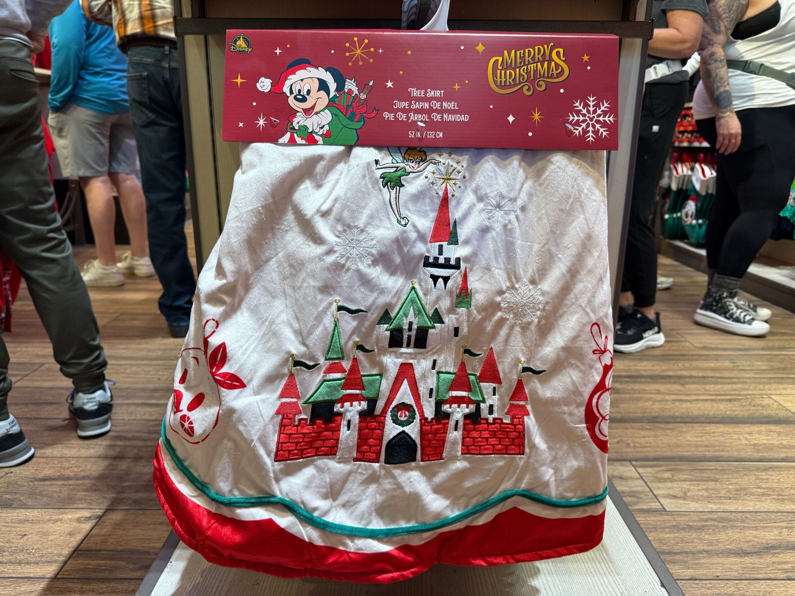 A Christmas tree skirt with a red and green castle motif, resembling Disneyland’s Sleeping Beauty Castle, is part of the Resort’s holiday merchandise.
