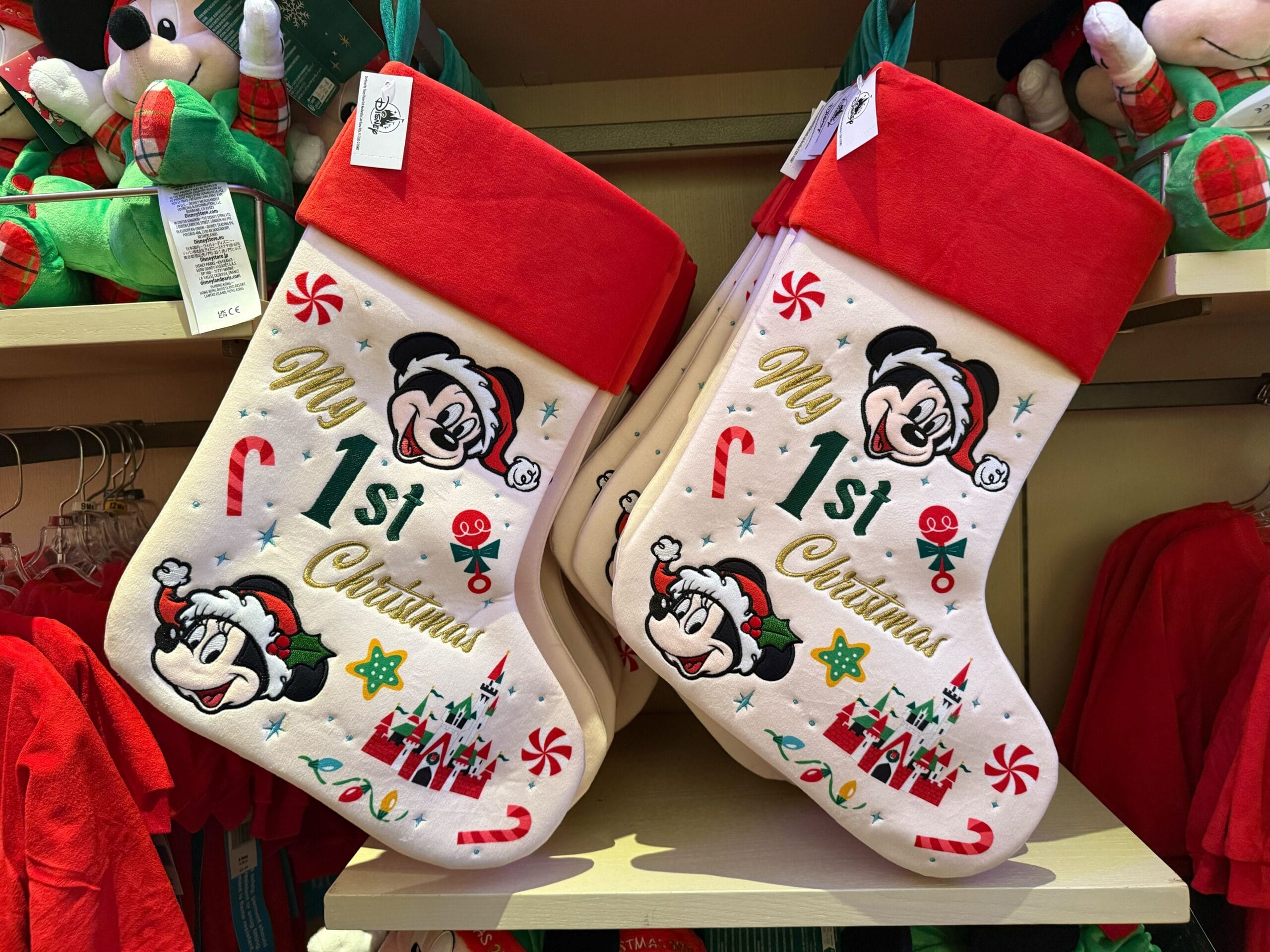Two Disneyland Christmas stockings featuring Mickey and Minnie Mouse hang on display, part of the park’s festive holiday merchandise.
