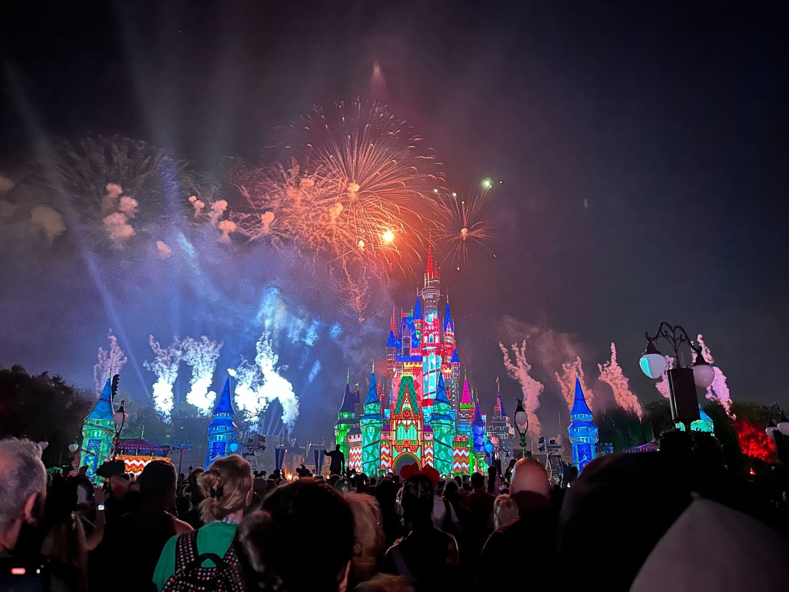 Vivid fireworks light up the night sky above Cinderella Castle, Magic Kingdom’s iconic centerpiece, as holiday projections transform it into a wrapped present.