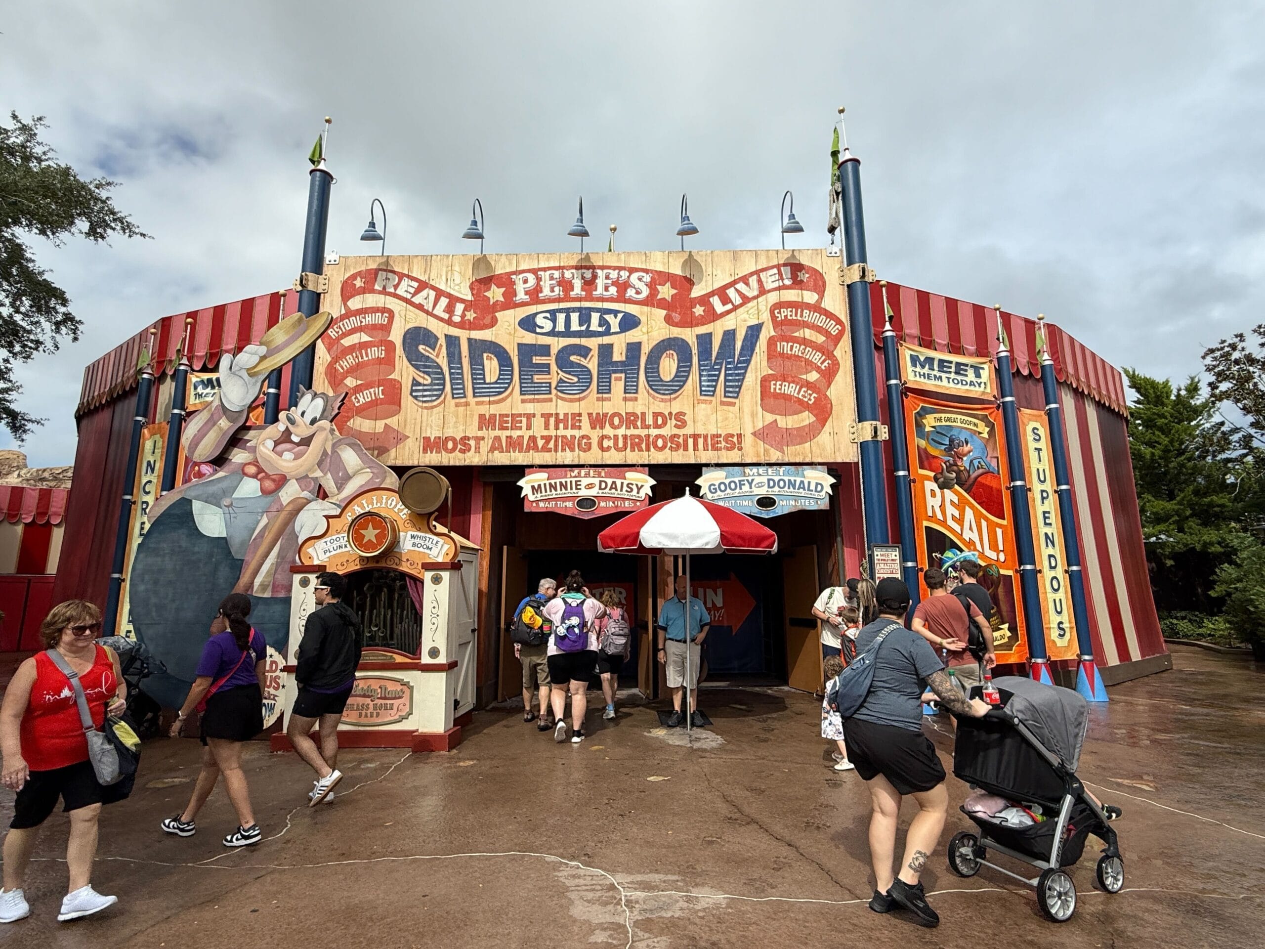 People walk past Pete's Silly Sideshow entrance at Magic Kingdom, where vibrant new banners replaced the old ones.