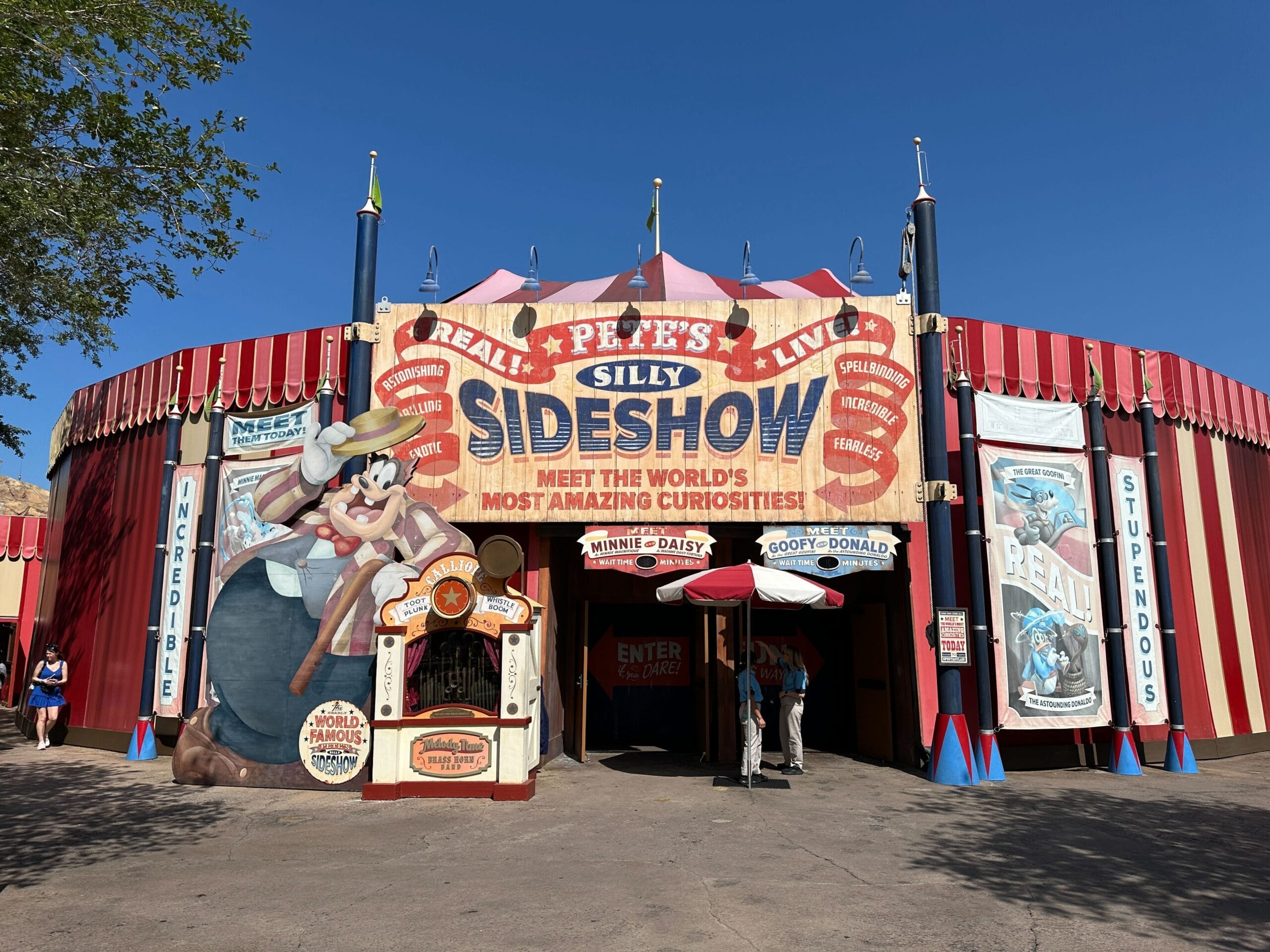 A colorful circus tent entrance labeled "Pete’s Silly Sideshow" with cartoon character decorations and banners.