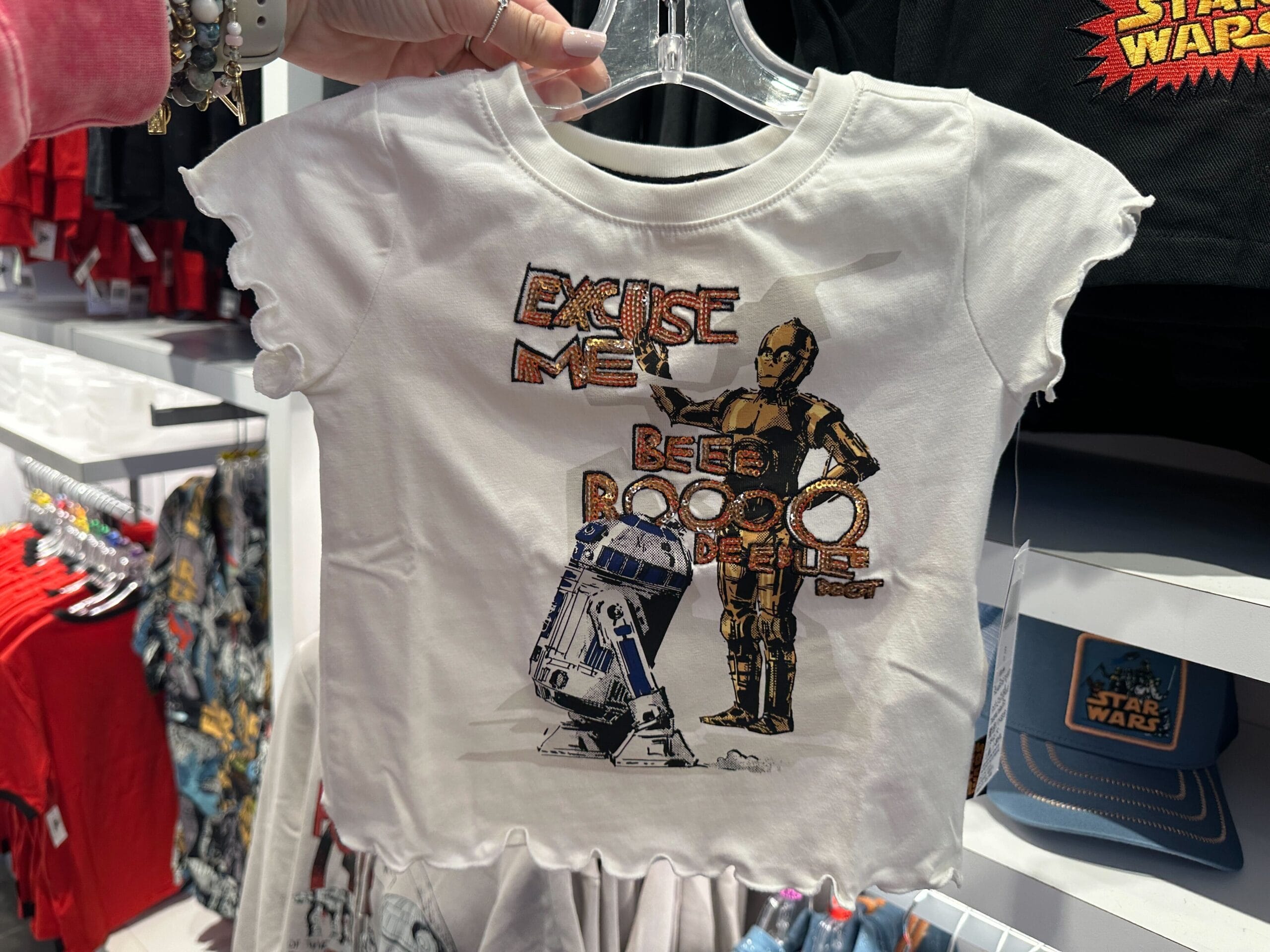 White kids’ Star Wars apparel featuring R2-D2, C-3PO, and the phrase: “Excuse me, beep boop beep boop.” No Disney castle.