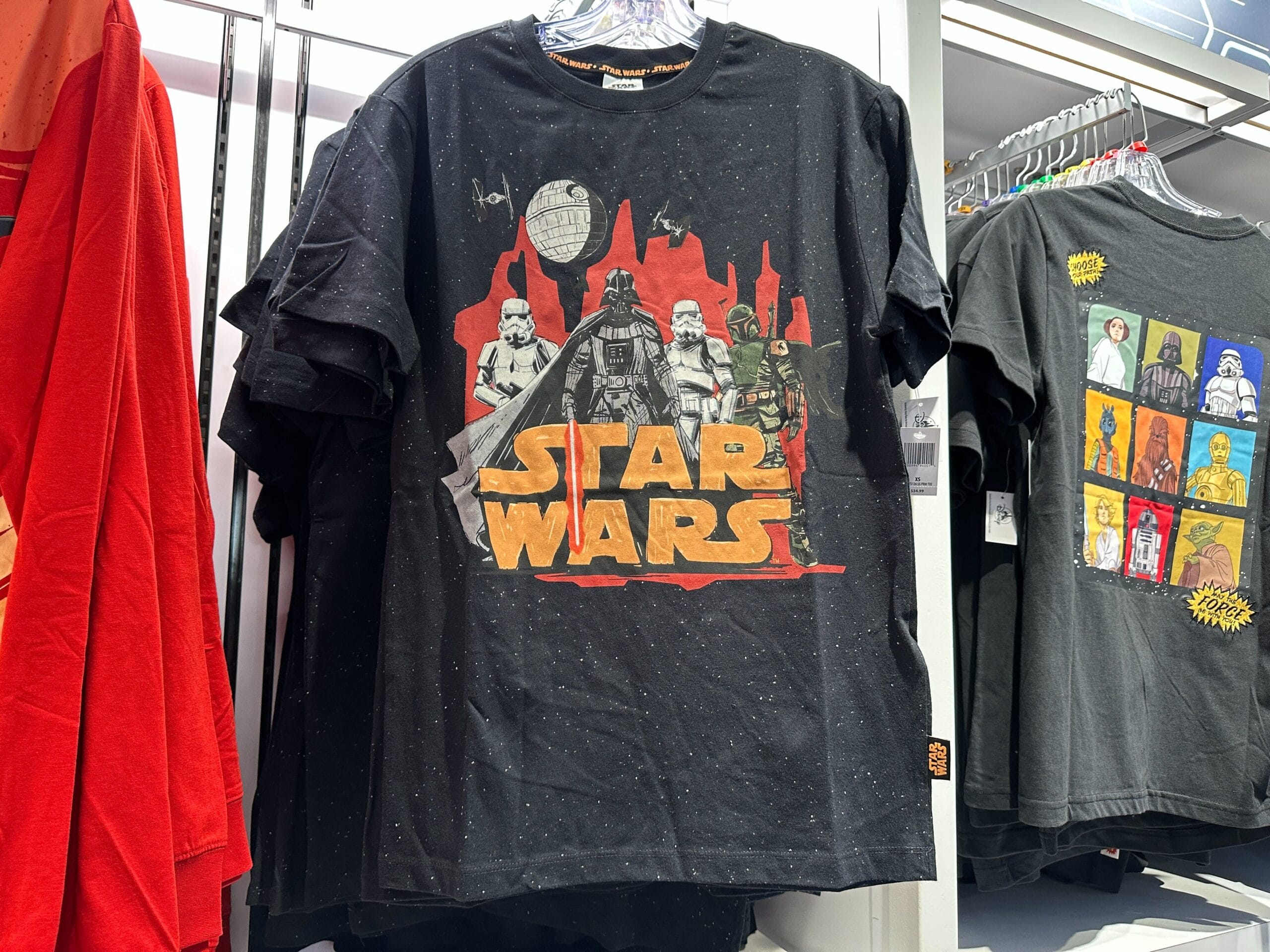 Black Star Wars tee with Darth Vader, stormtroopers, Death Star, and orange silhouettes—no Disney castle like those in parks.