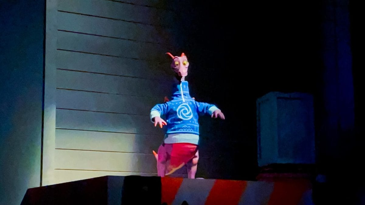 Figment the purple dragon wears his festive holiday sweater at EPCOT, with no castle backdrop like at other Disney parks worldwide.