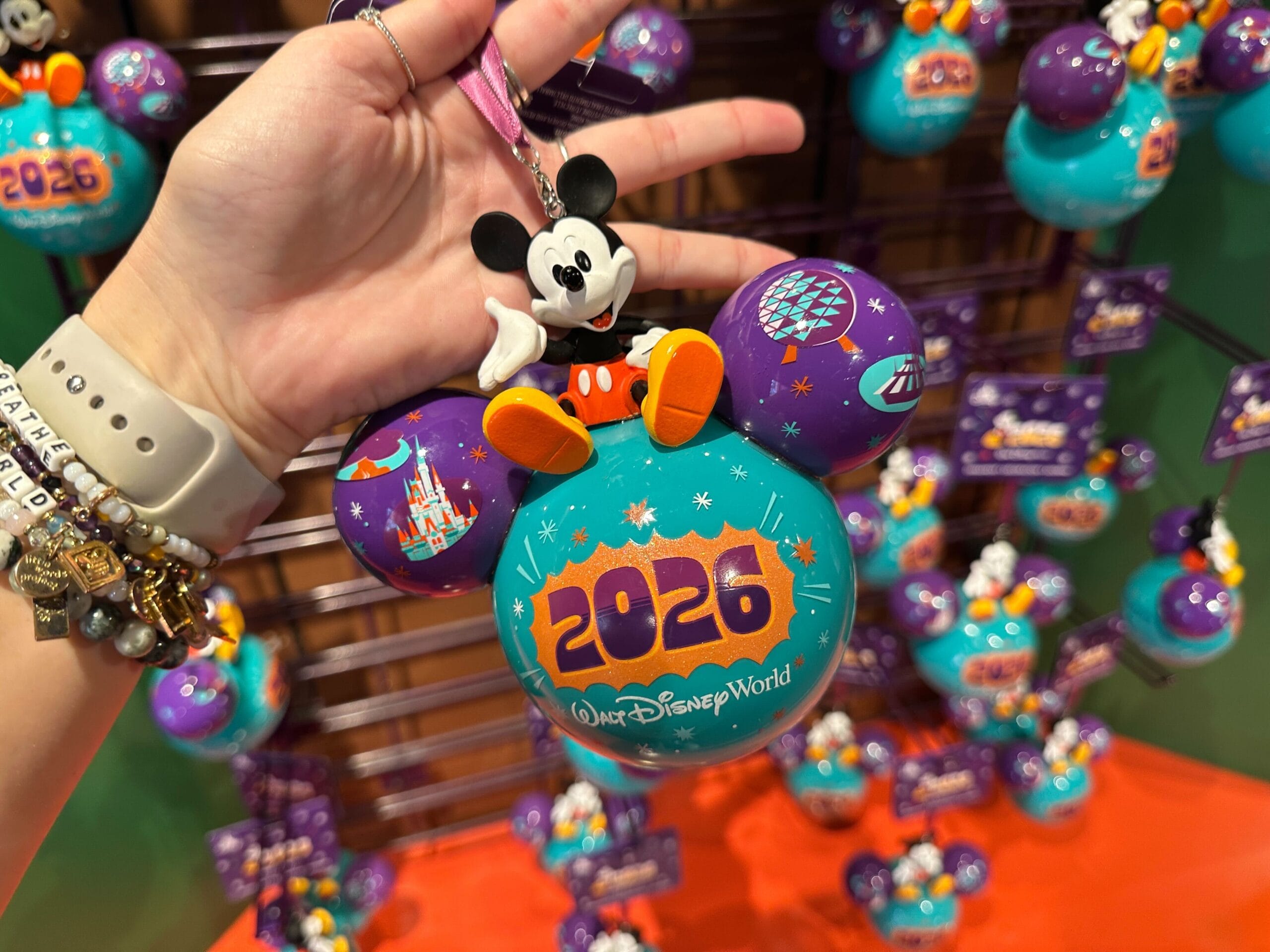 This Mickey-shaped purple and teal bauble ornament reads “2026 Walt Disney World.” The back reads, “The Most Magical Place on Earth.”