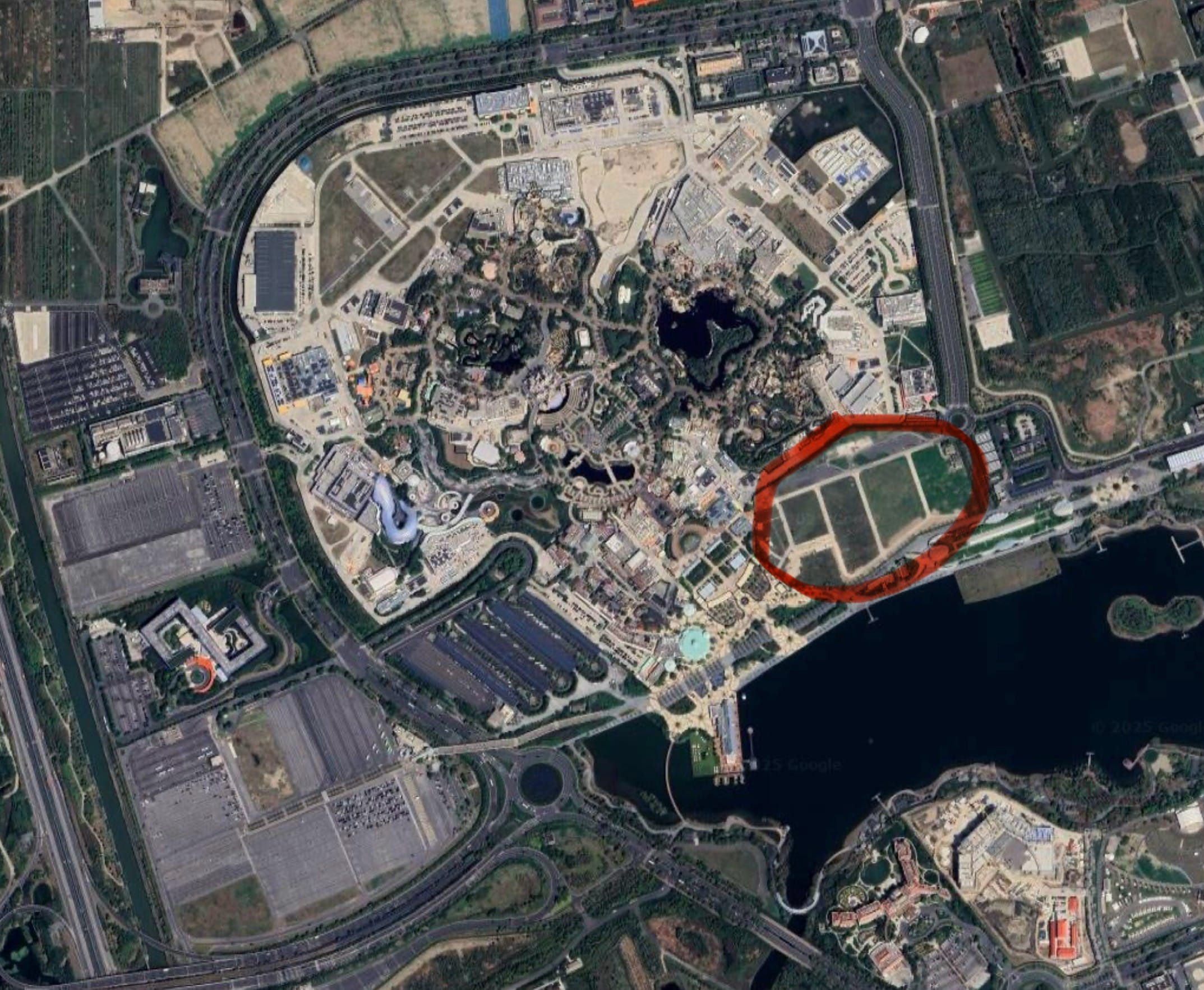 Aerial view of Shanghai Disney Resort with red-outlined area near Park Entrance Hotel, no castle seen to compare with other Disney parks.