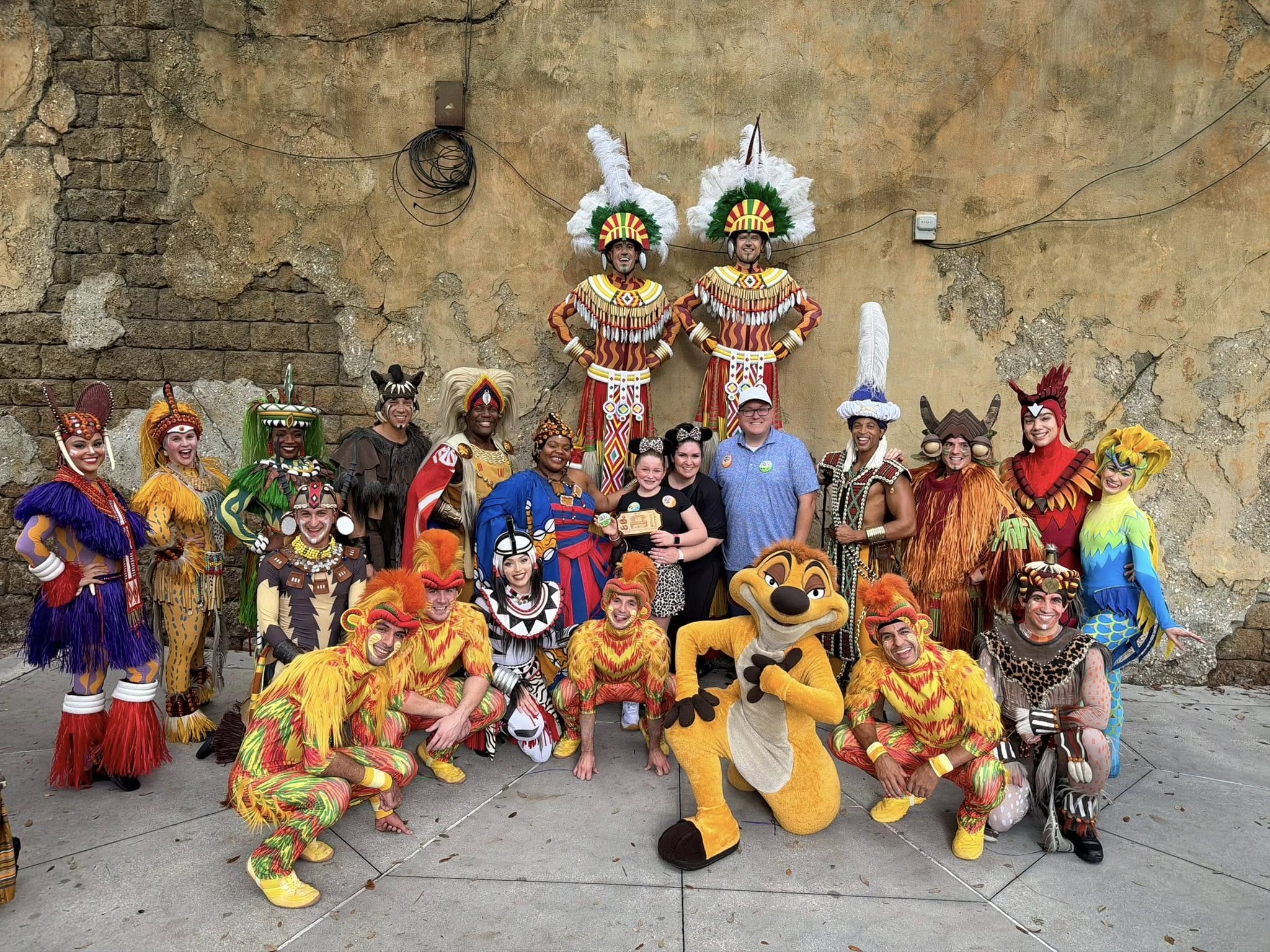 Performers in colorful Lion King costumes pose with guests at Animal Kingdom, one of Walt Disney World’s most lively stage shows.