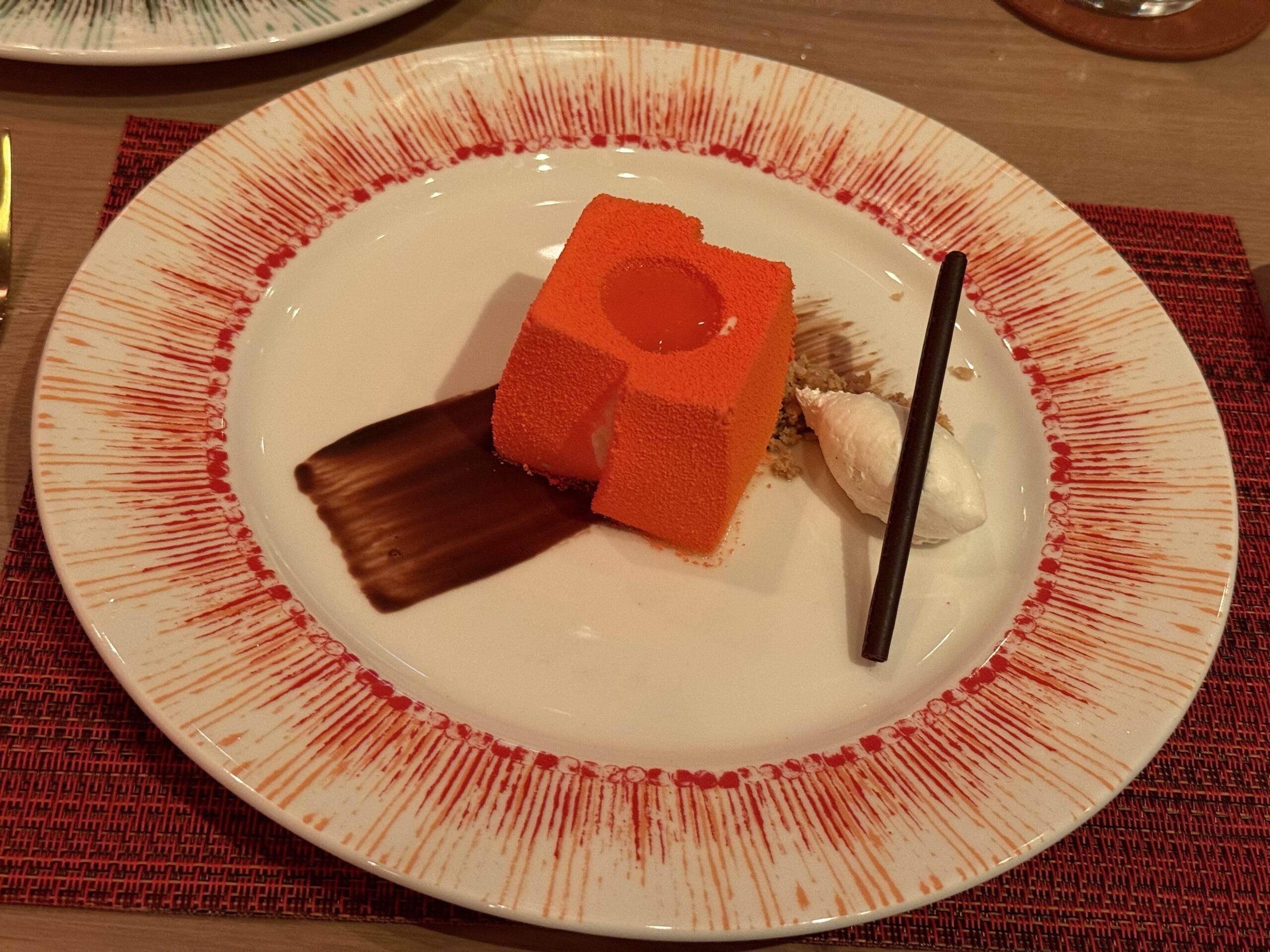 The cheesecake dessert has Vanilla Cheesecake, Orange Mousse, Orange Segment Glaze, and Chocolate Sauce