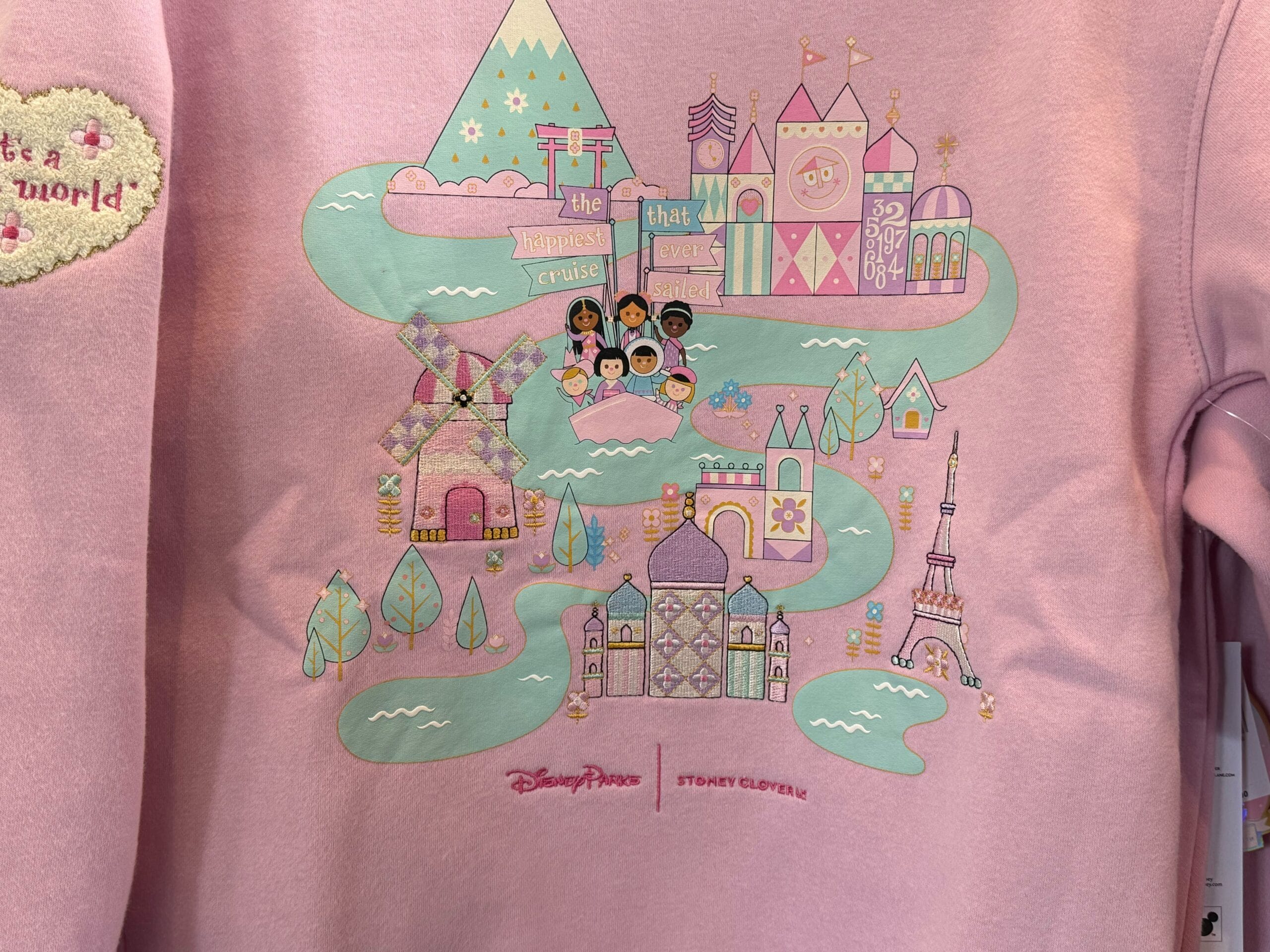 a close up of the front of the it's a small world sweatshirt