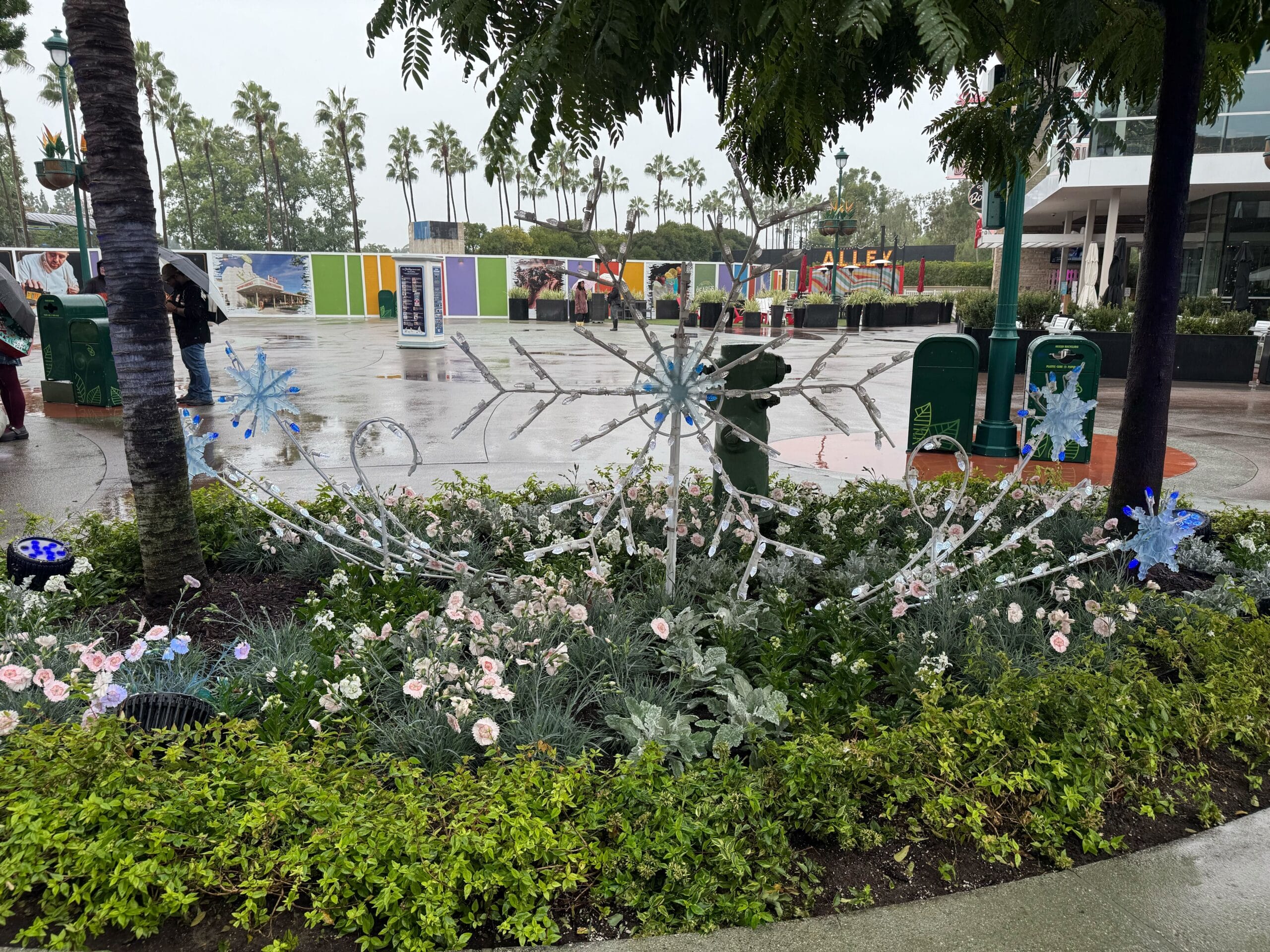 Another flowerbed features trees adorned with shiny gold baubles.