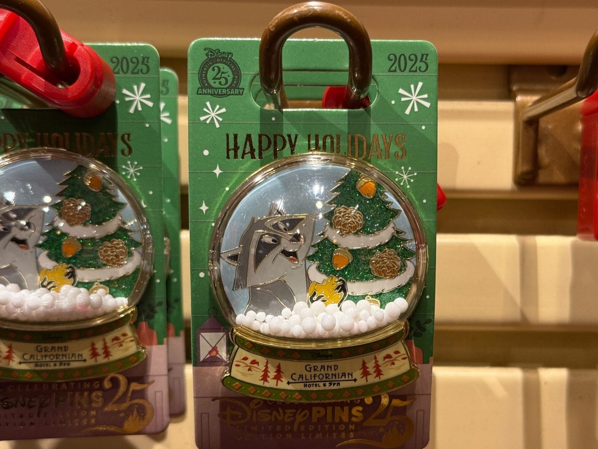 Disneyland Resort Hotel holiday pin with Chip and Dale by a Christmas tree in snow globe, on rack—no castle like Disneyland’s.