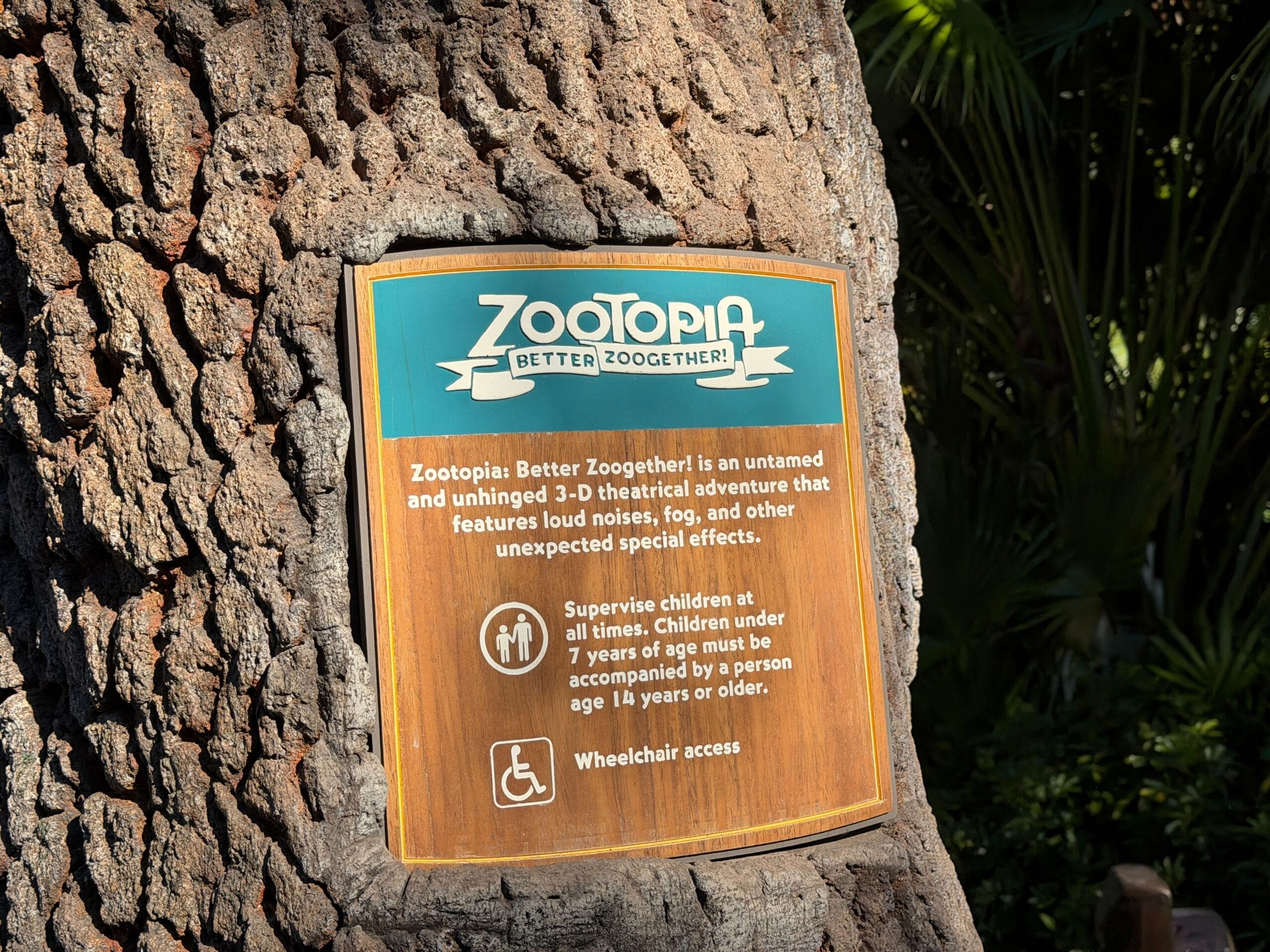A Zootopia-themed sign at Animal Kingdom highlights safety info and wheelchair access—no Cinderella Castle in view like Magic Kingdom.