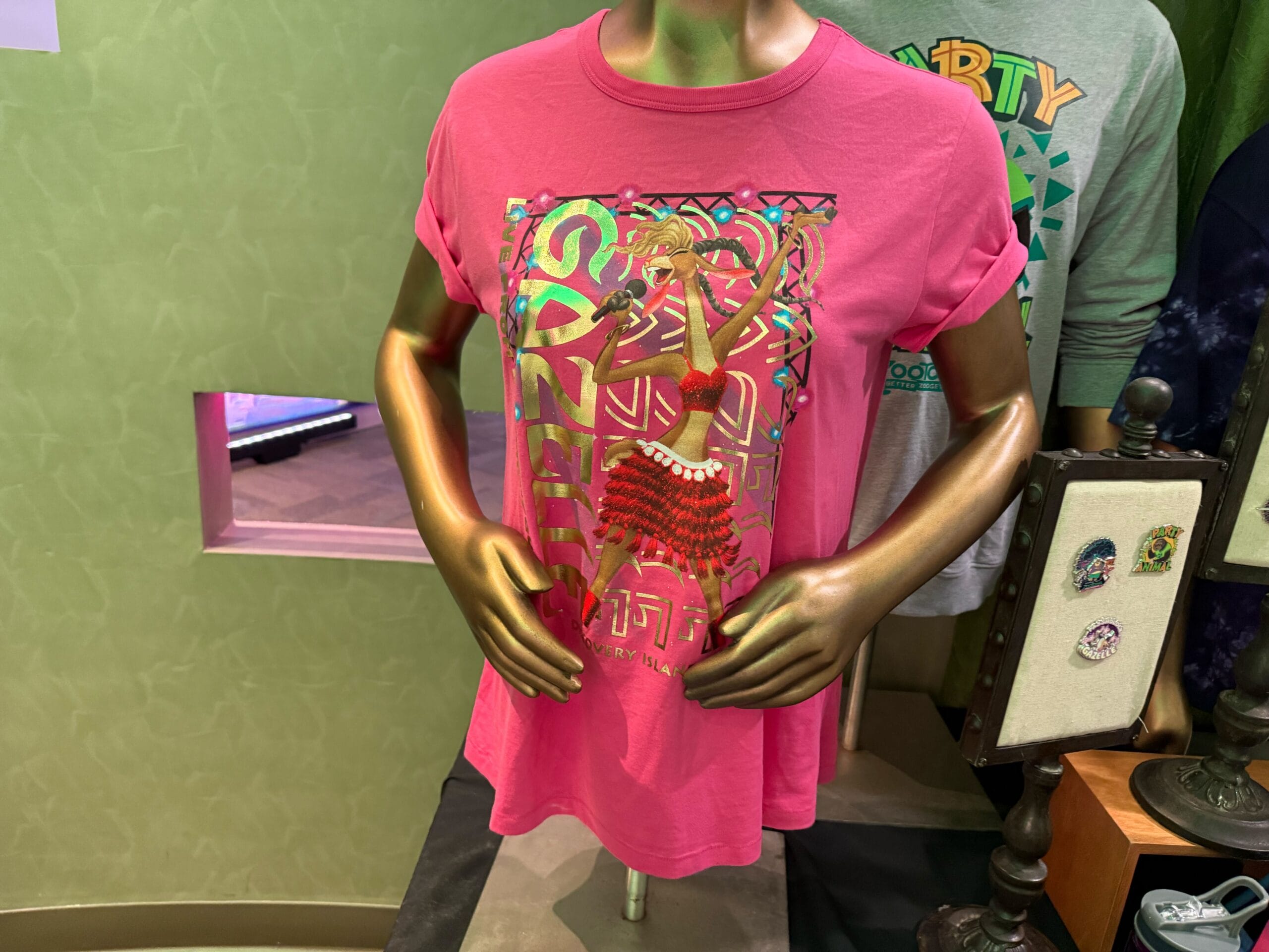 Pink T-shirt featuring Kuzco as a llama in vibrant, Aztec-style gear, reminiscent of festive Disney Parks merchandise designs.