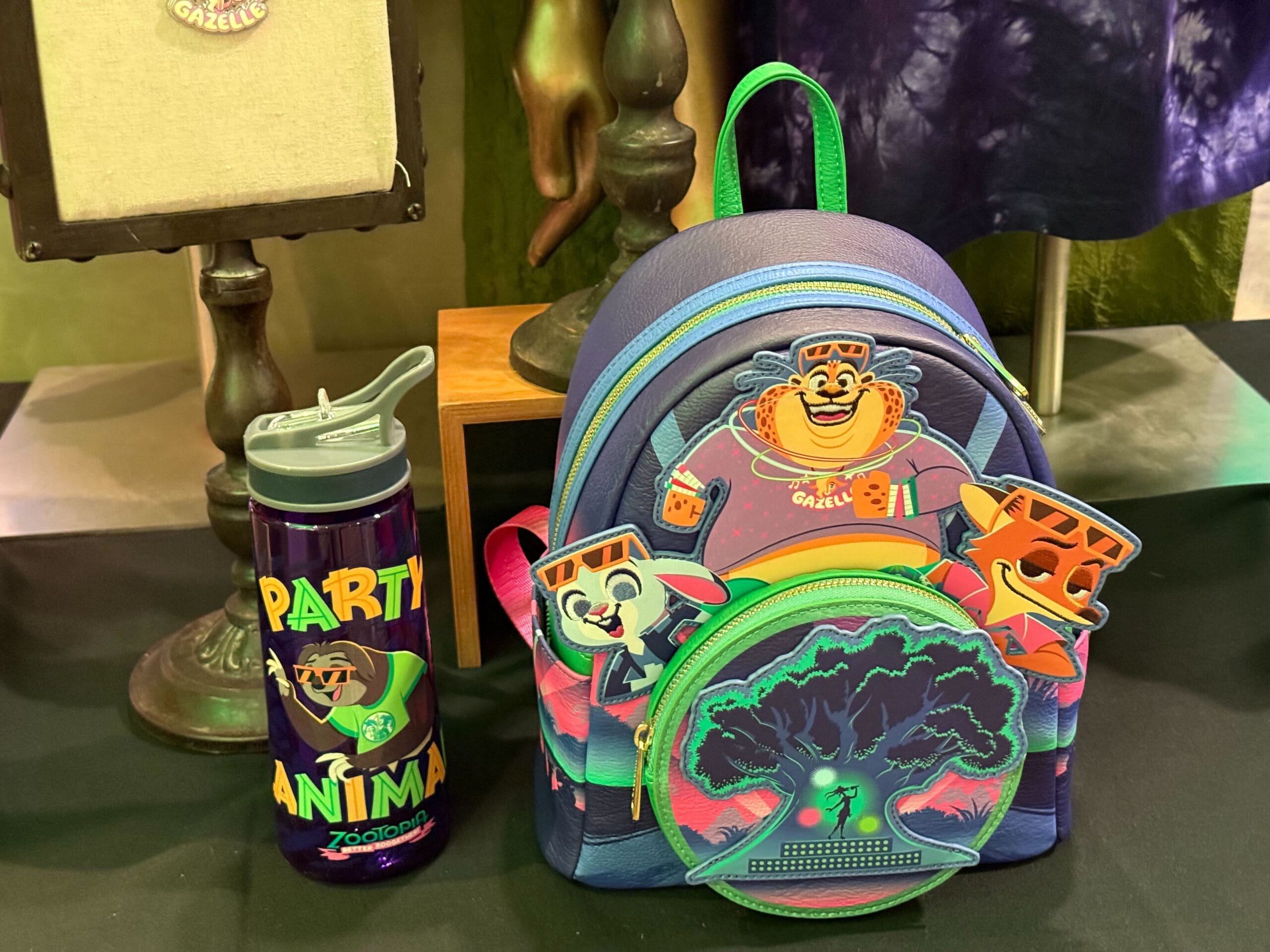 A vibrant Zootopia backpack and water bottle with Disney cartoon animals, reminiscent of souvenirs from Disneyland gift shops.
