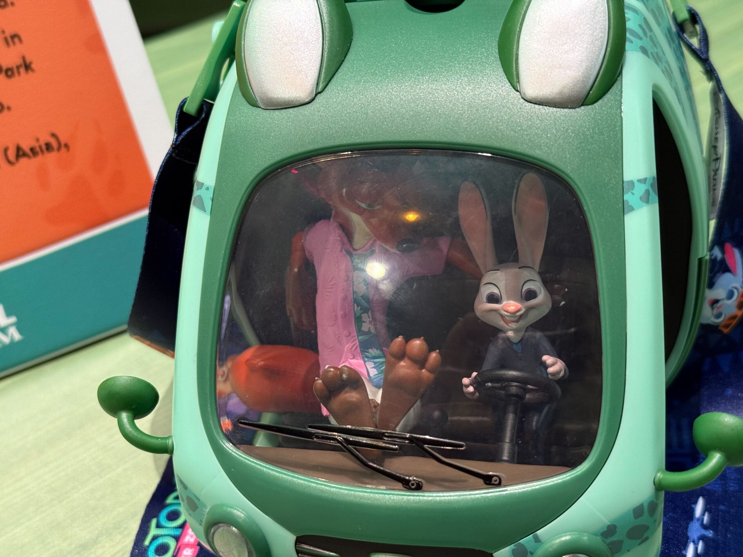 Zootopia fox and rabbit toy figures sit in a green vehicle, just like you'd find at a Disney park shop