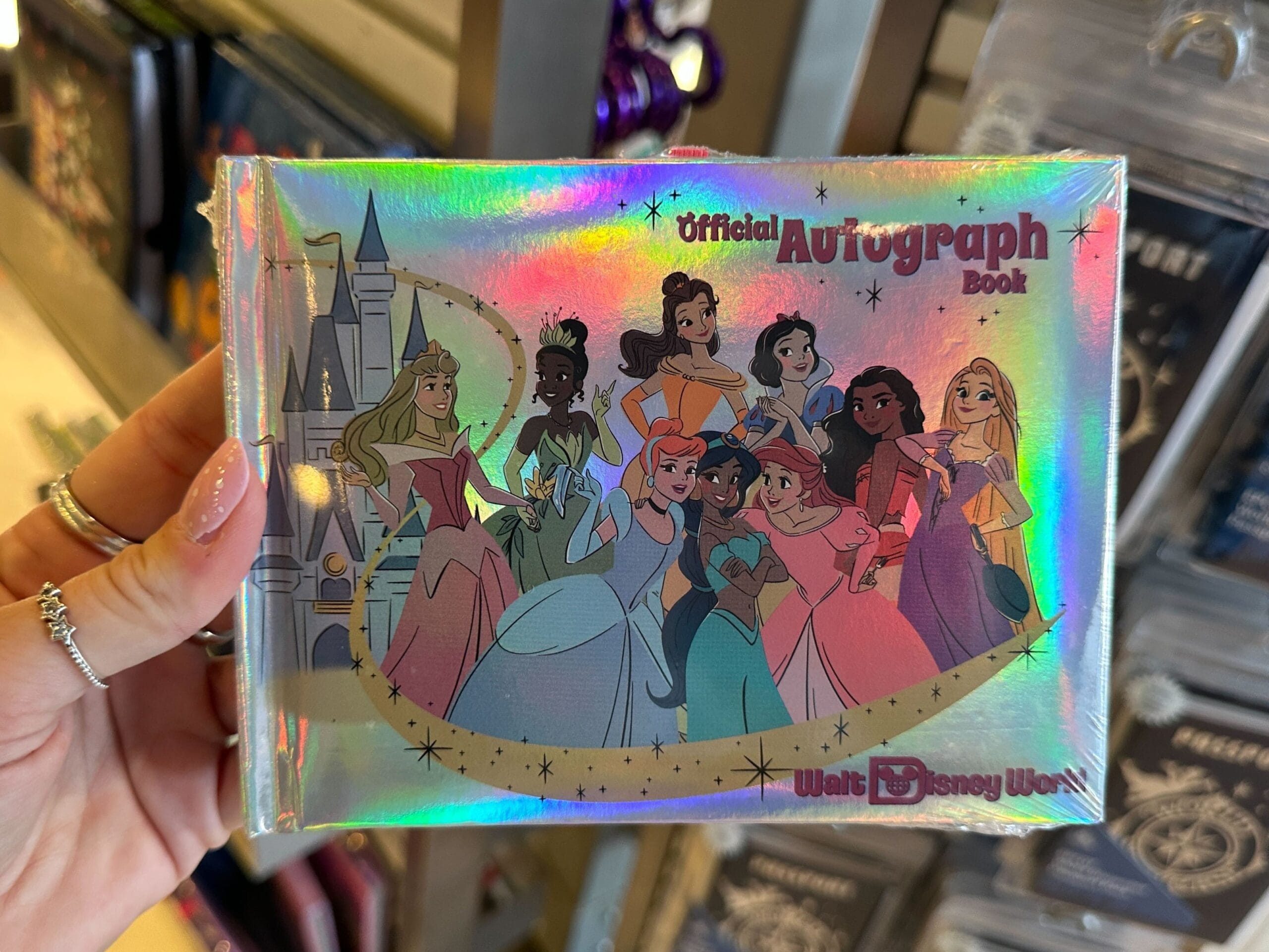 Disney Princess autograph book front cover featuring Aurora, Tiana, Belle, Snow White, Moana, Rapunzel, Cinderella, Jasmine, and Ariel.