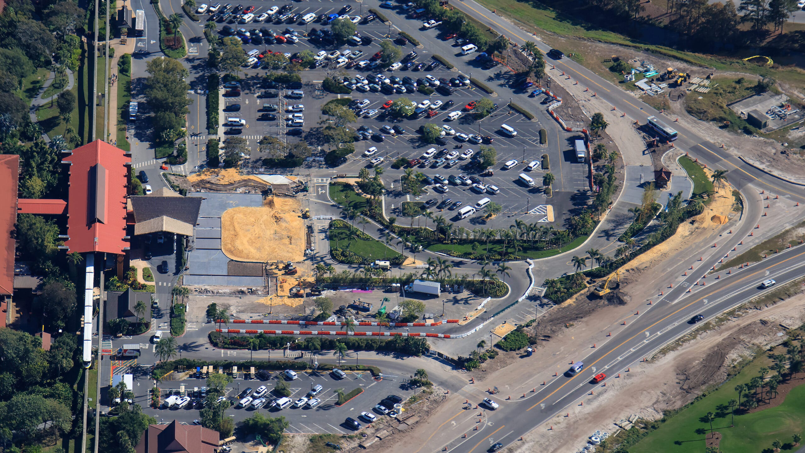 The image shows continued construction at the resort's main entrance, including new pavement.