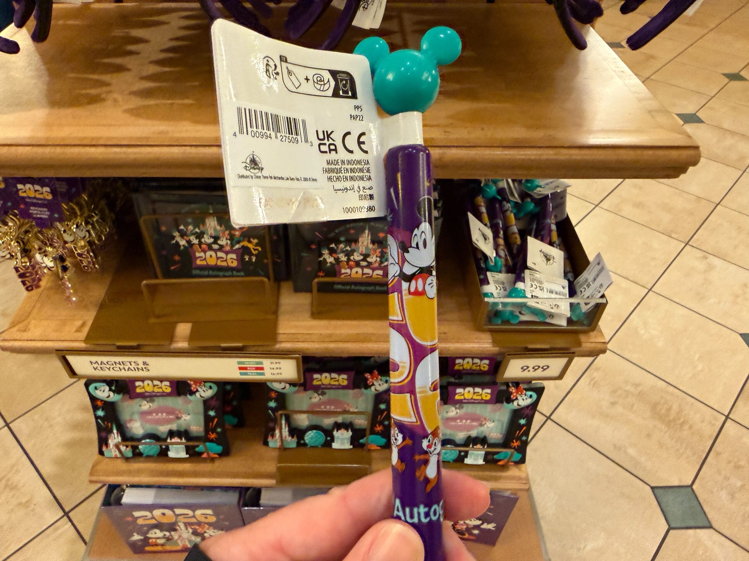 The pen is purple with an aqua-colored Mickey end. "2026" is in yellow ombré around the sides with Mickey and friends.