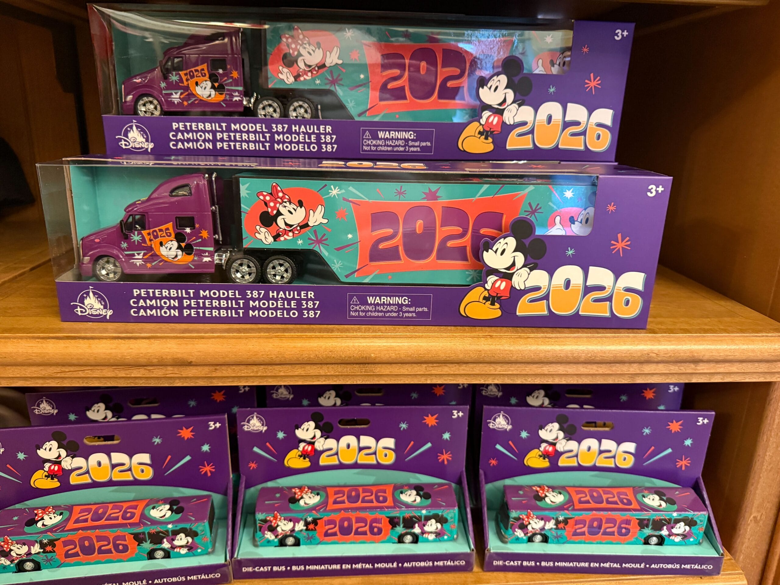 The truck toy has a purple cab and an aqua-colored trailer, both featuring the year, Mickey, and Minnie.