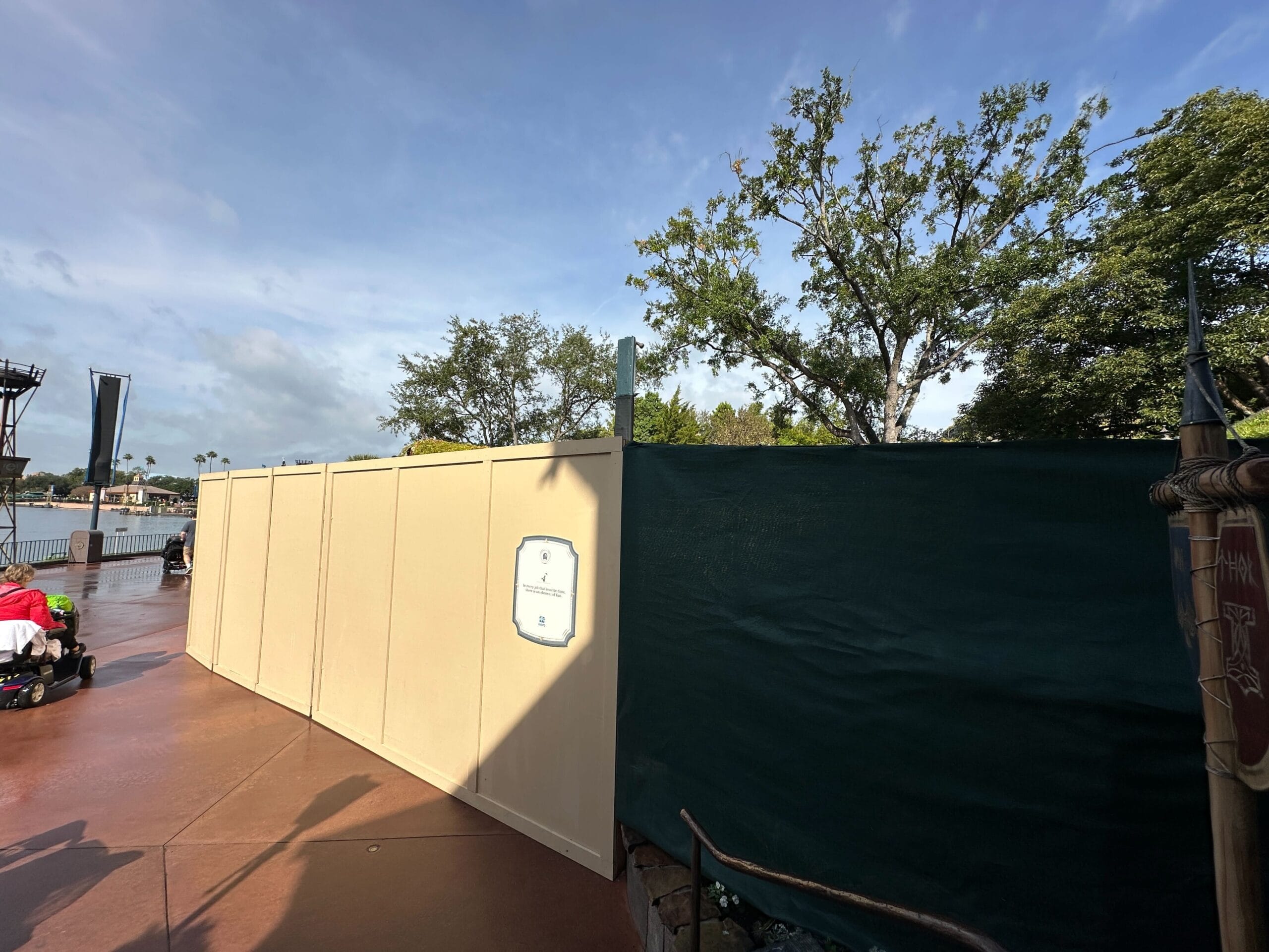 Construction walls take up a large swath of walkway at the Norway pavilion of EPCOT, surrounding the site of a drink cart.