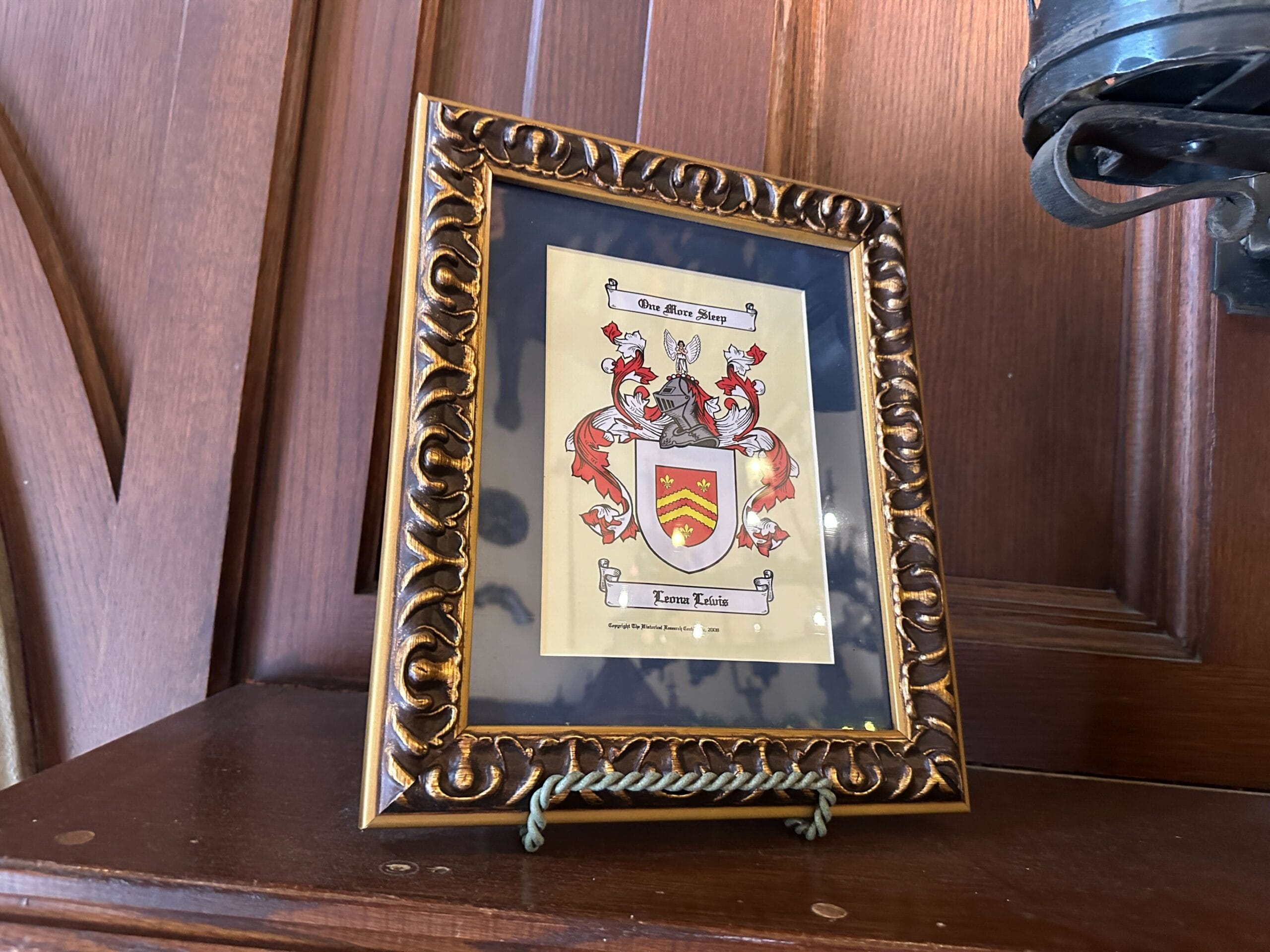 This red, white, and yellow crest has the text "One More Sleep" and Leona Lewis' name, representing her 2013 single from the album Christmas, with Love.