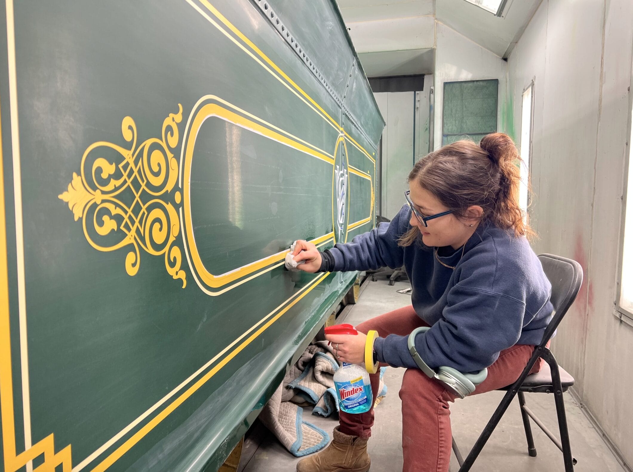 Cast Member hand-paints detailing and gold leafing on the steam train