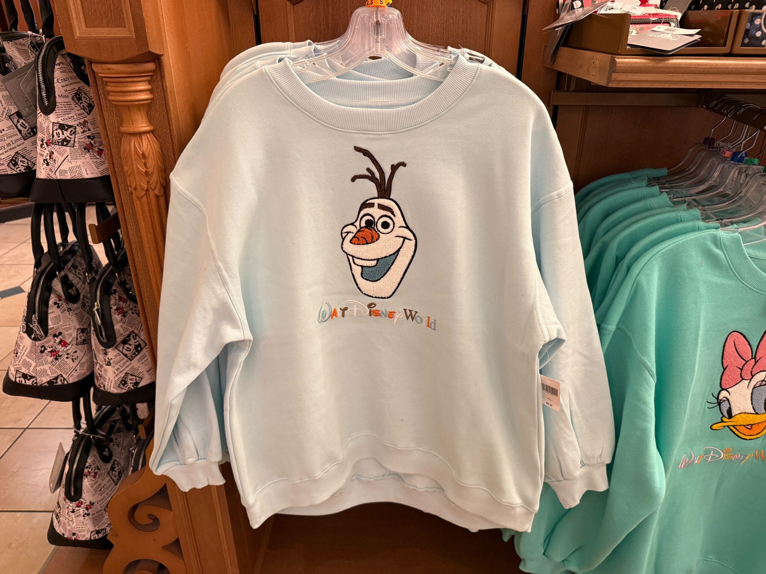Olaf and the Cheshire Cat have arrived at Disney World in the form of character sweatshirts.