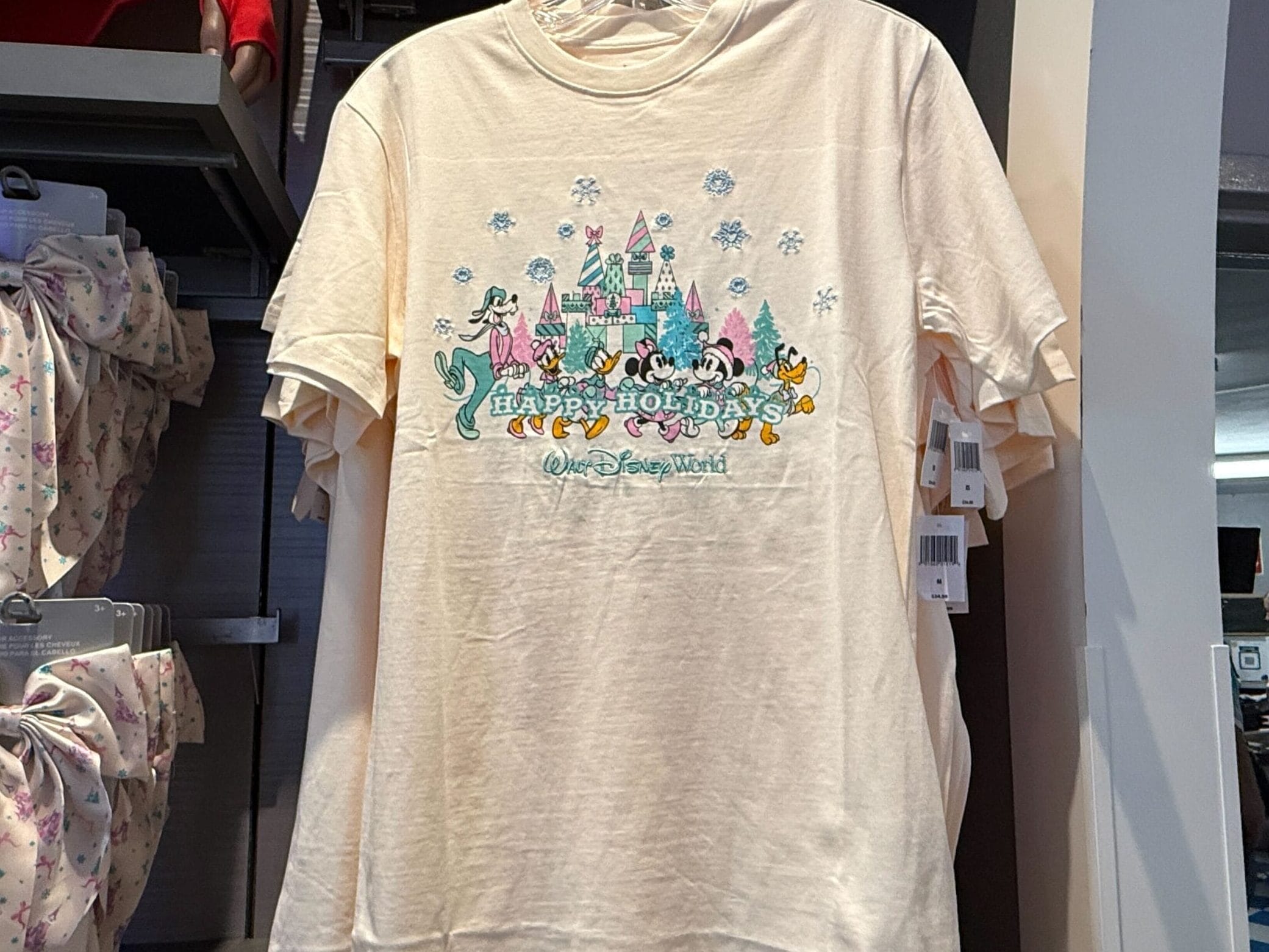 Goofy, Daisy, Donald, Minnie, Mickey, and Pluto are dressed in matching winter attire and carrying a letter banner that spells out “Happy Holidays.”