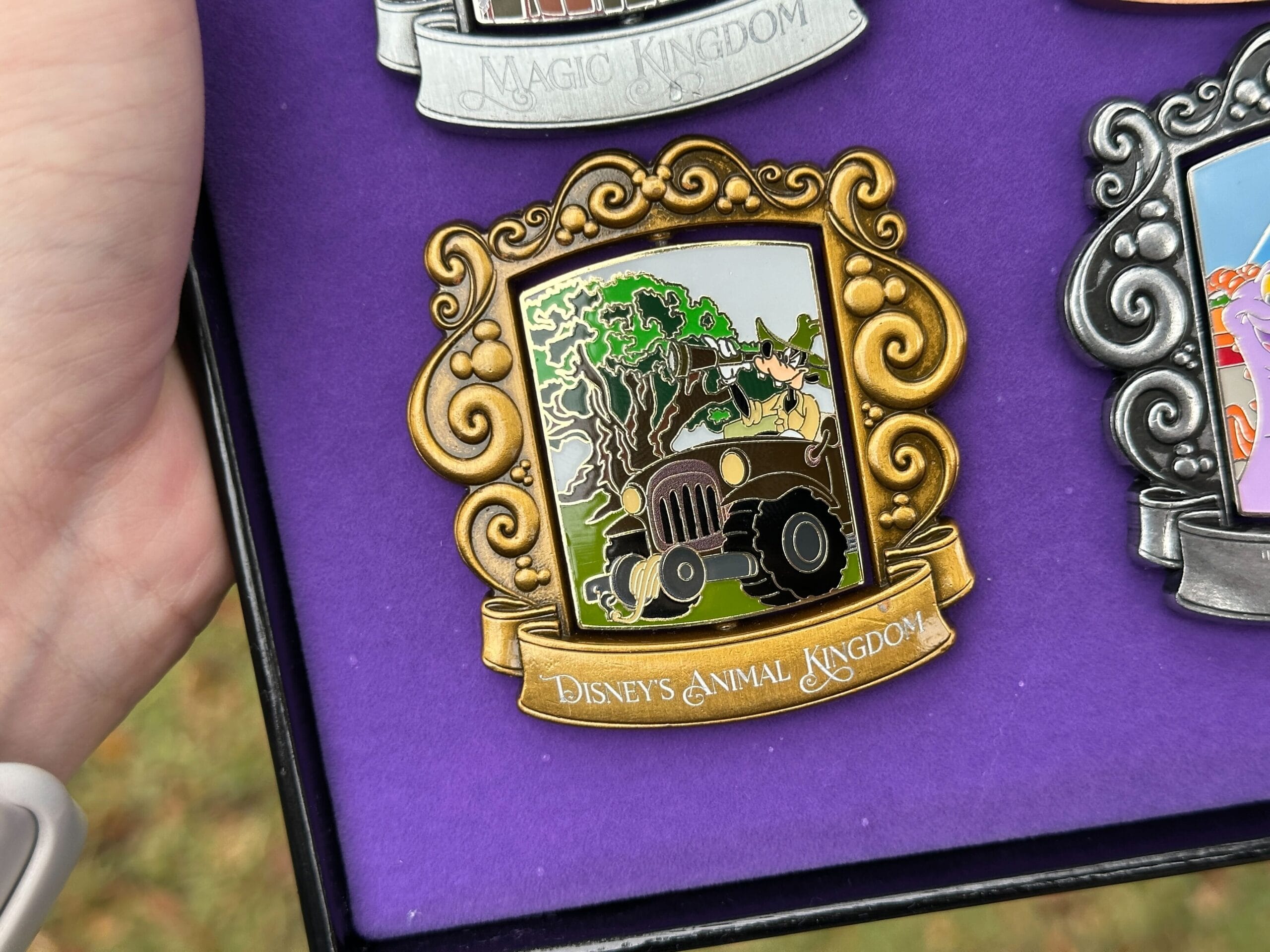 Goofy is pictured in safari gear driving a truck driving past the tree.